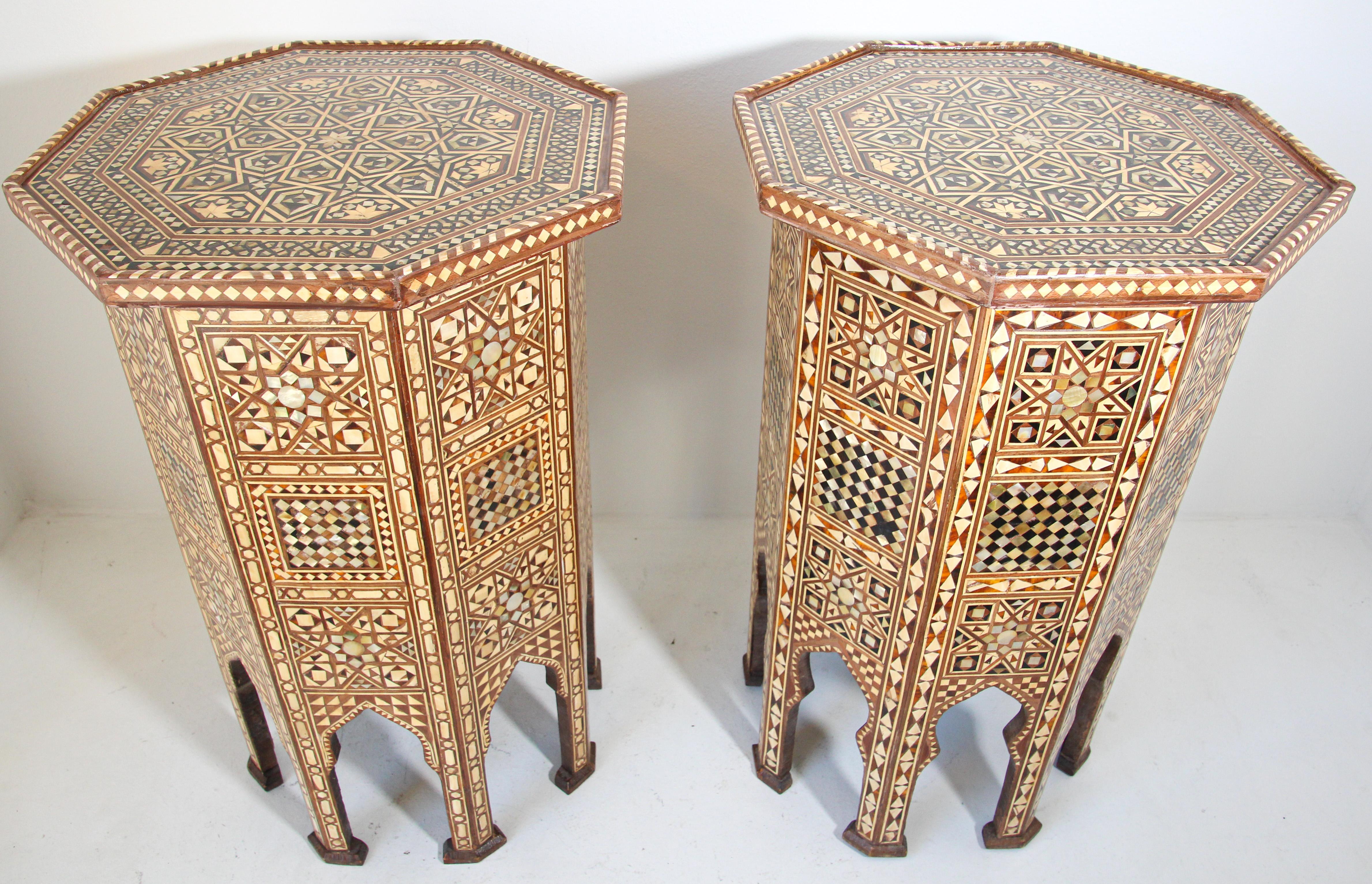 Pair of Moroccan Moorish style walnut octagonal pedestal tables inlaid with mosaic marquetry.
Tabletop is of octagonal form, decorated with various geometric and arabesque designs.
The table is standing on eight legs separated by cusped and engraved