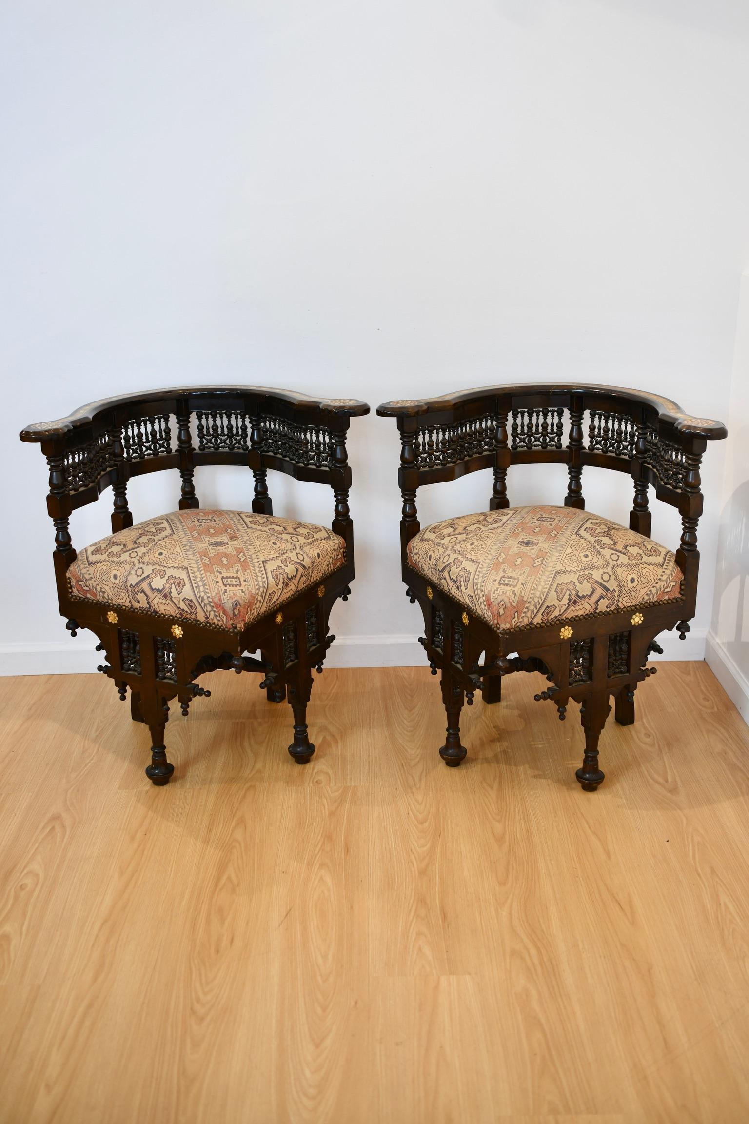 Moorish corner carved walnut chair with mother of pearl inlay and upholstered seat. Two available, sold individually. One with some fraying to upholstery, pictured. Dimensions: 30.75