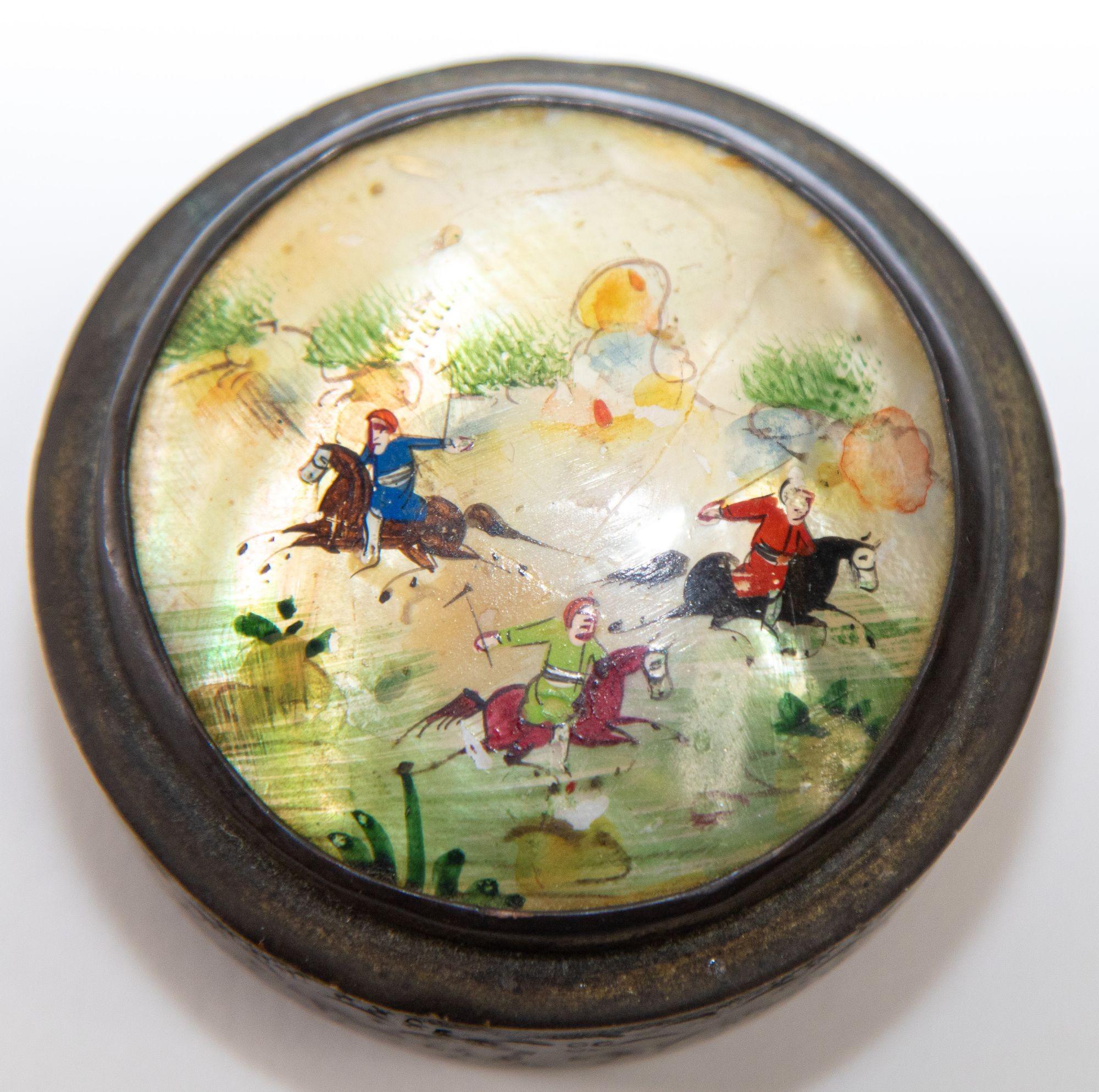 Vintage round brass pill box with lid shell inlaid and miniature hand-painted with Persian polo sport scene.
Beautiful and unusual round metal pill box or snuff box with a pearlescent inset and hand-painted motif of Persian riders playing polo.
The