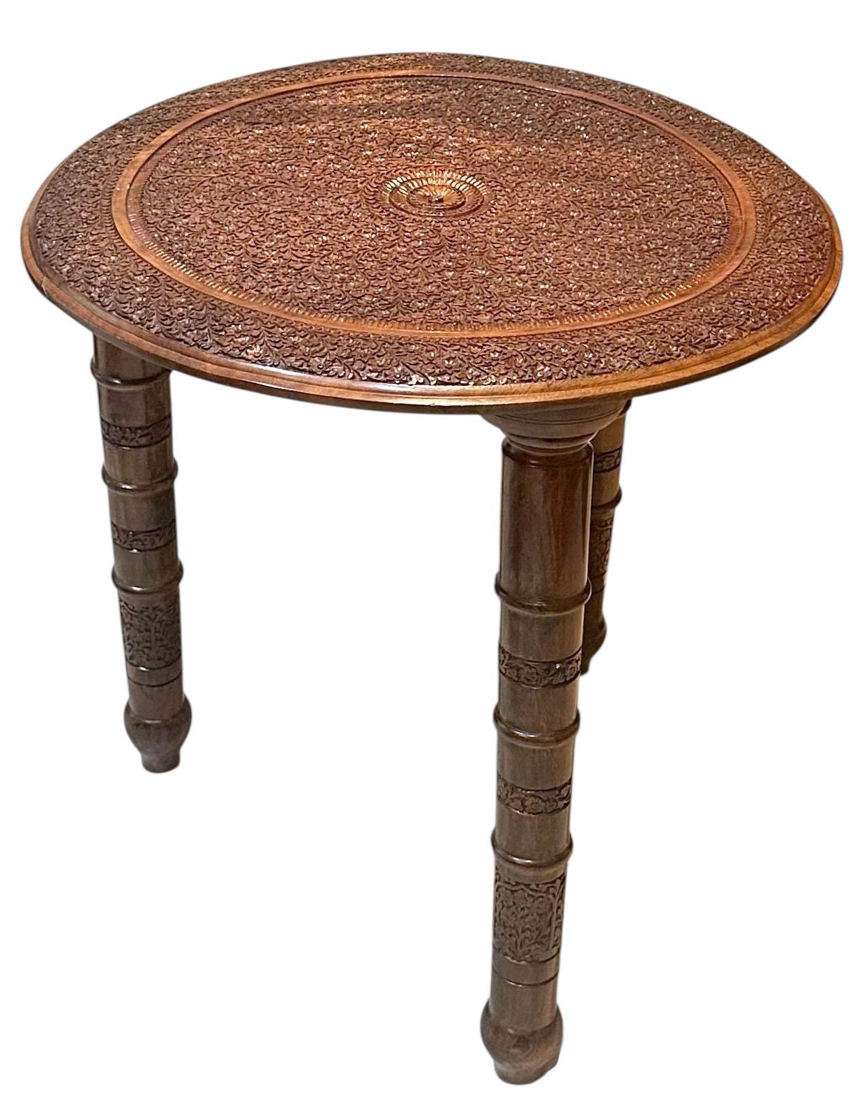Un tavolino indiano eccezionalmente intagliato in stile moresco, risalente all'inizio del XX secolo. Il tavolo presenta intricati dettagli intagliati a mano, con motivi geometrici che riflettono l'influenza del design tradizionale