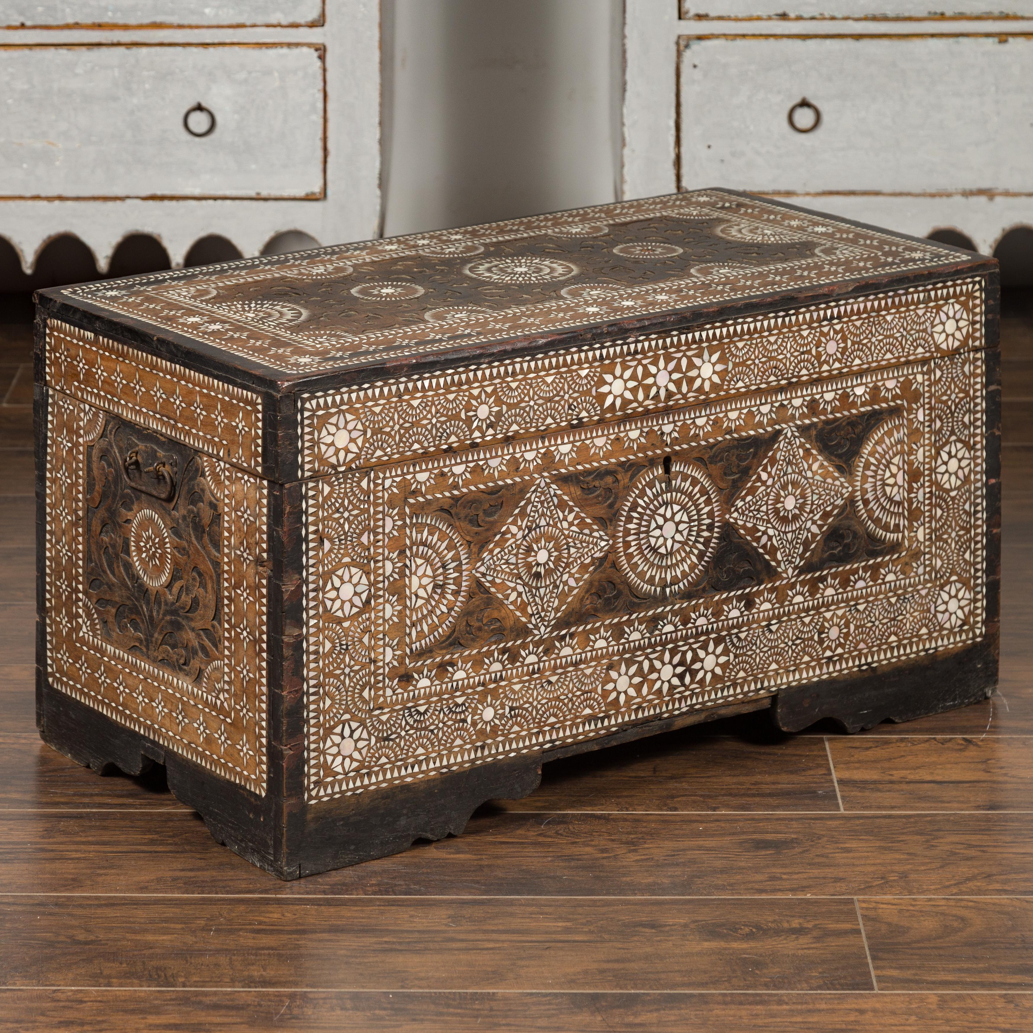 A Syrian Moorish style blanket chest from the early 20th century, with geometric mother of pearl inlay. Born during the first quarter of the 20th century, this blanket chest features a linear silhouette, perfectly decorated with an abundance of