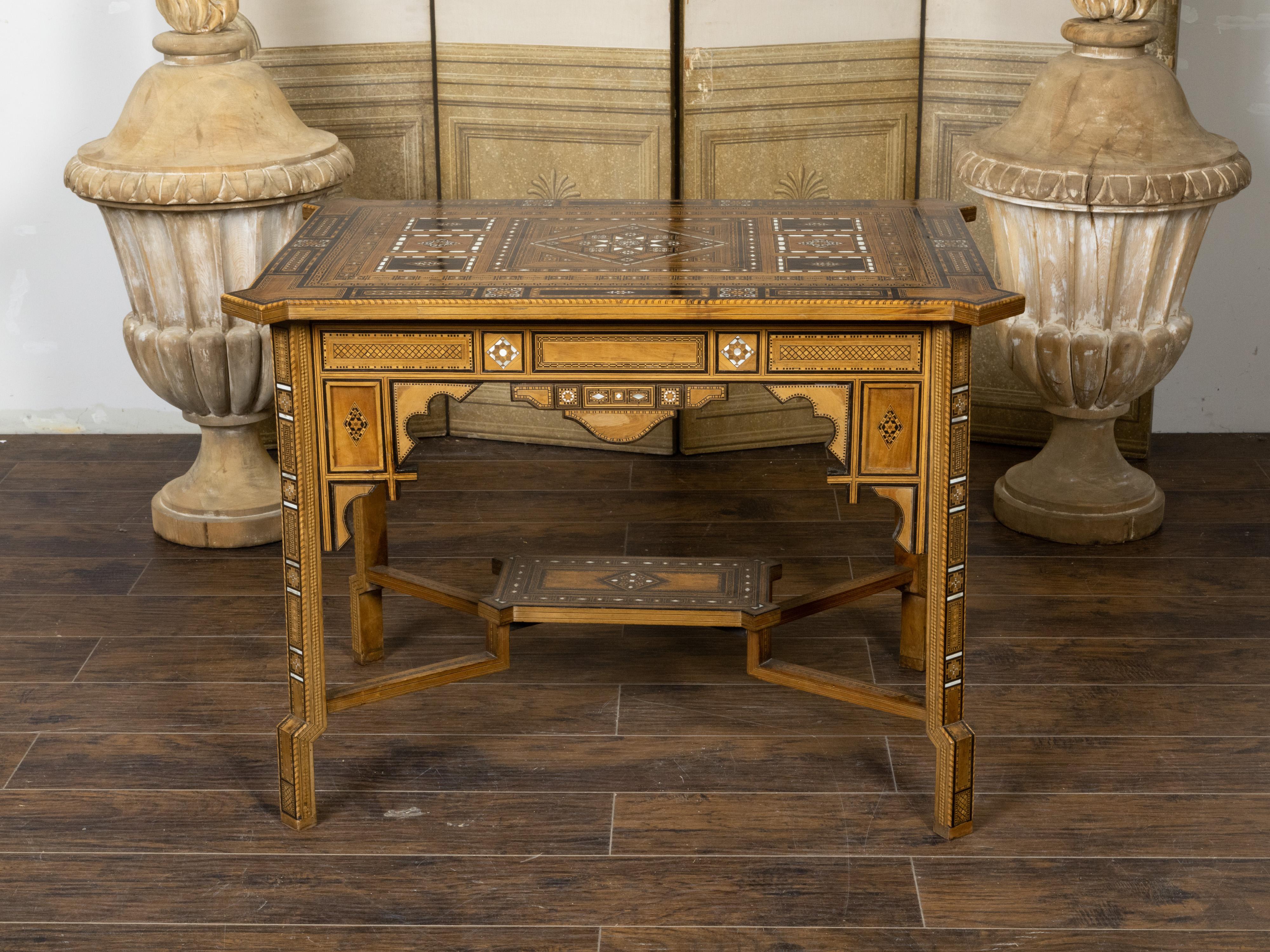 A Moroccan Moorish style center table from the early 20th century, with inlaid wood and mother of pearl geometric motifs. Created in Morocco during the first quarter of the 20th century, this Moorish style center table captures our attention with