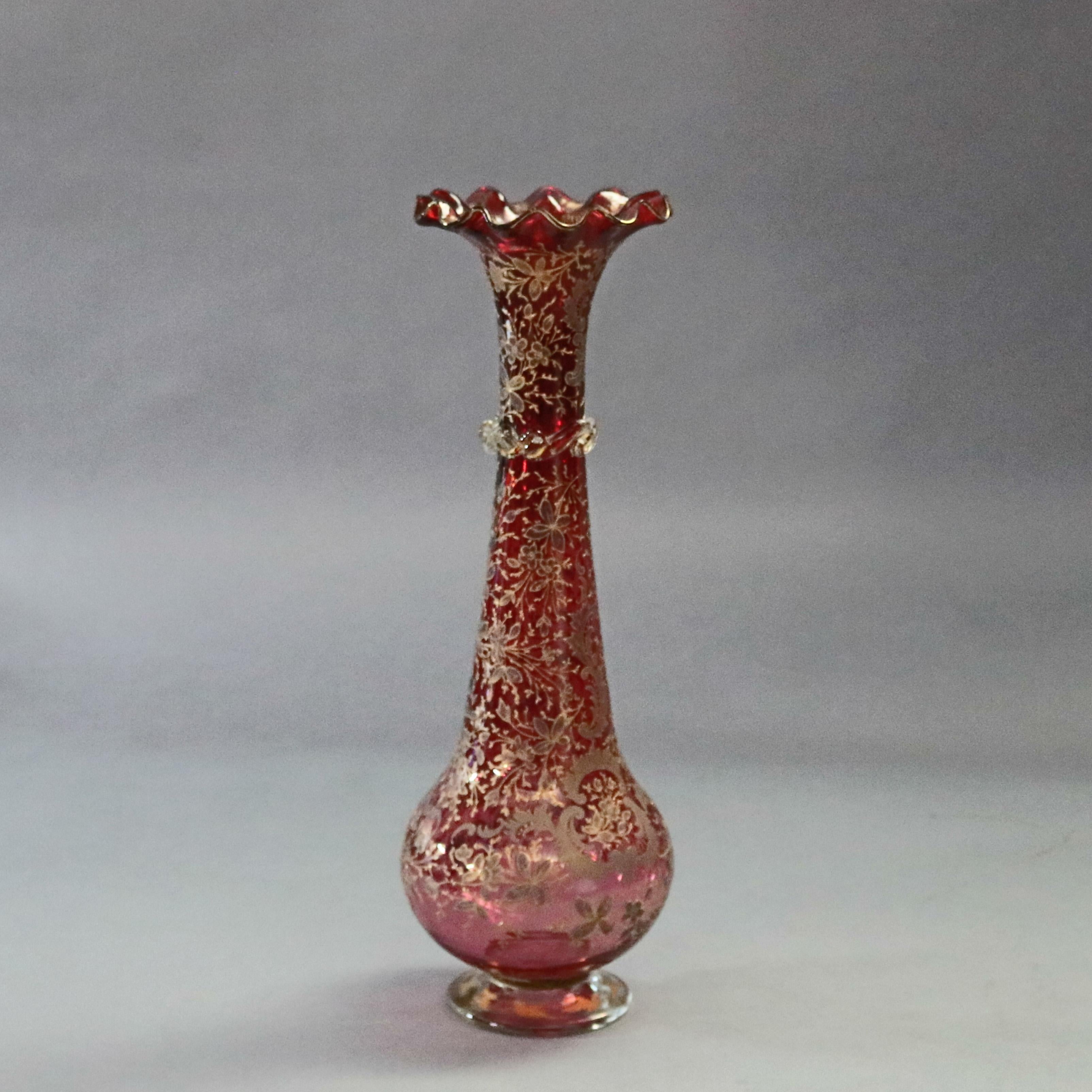 A Bohemian ruby glass vase offers mouth blown genie bottle form with foot, ruffled rim and collar and having allover gilt foliate and scroll Moorish design and open pontil, circa 1880

***DELIVERY NOTICE – Due to COVID-19 we are employing NO-CONTACT