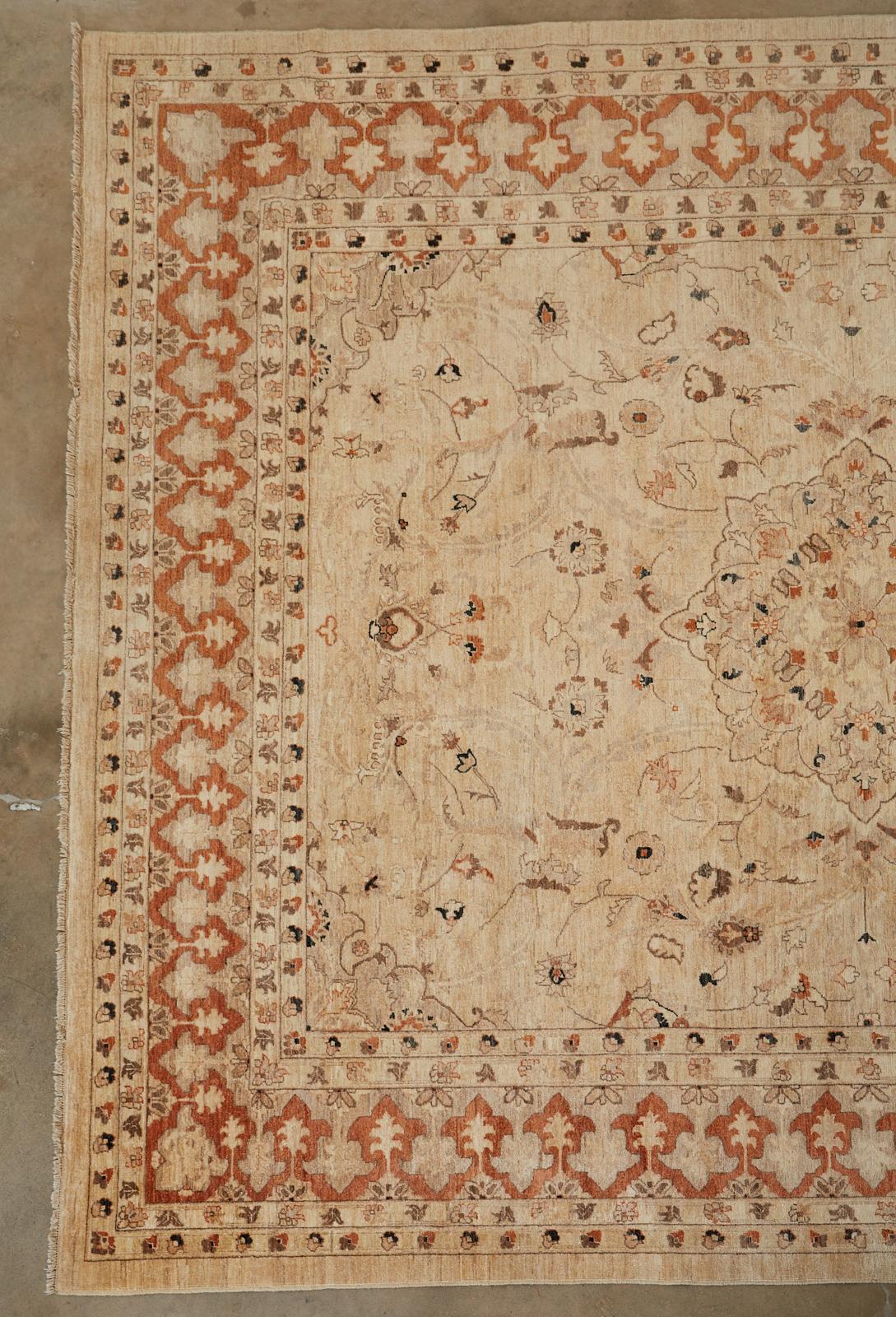 Distinctive vintage hand knotted wool Turkish Oushak rug. Large rug with a beige field having a medallion encircled by free form floral and vines. The border features an arabesque or Moorish style fleur-de-lis shaped reverse design in a burnt sienna