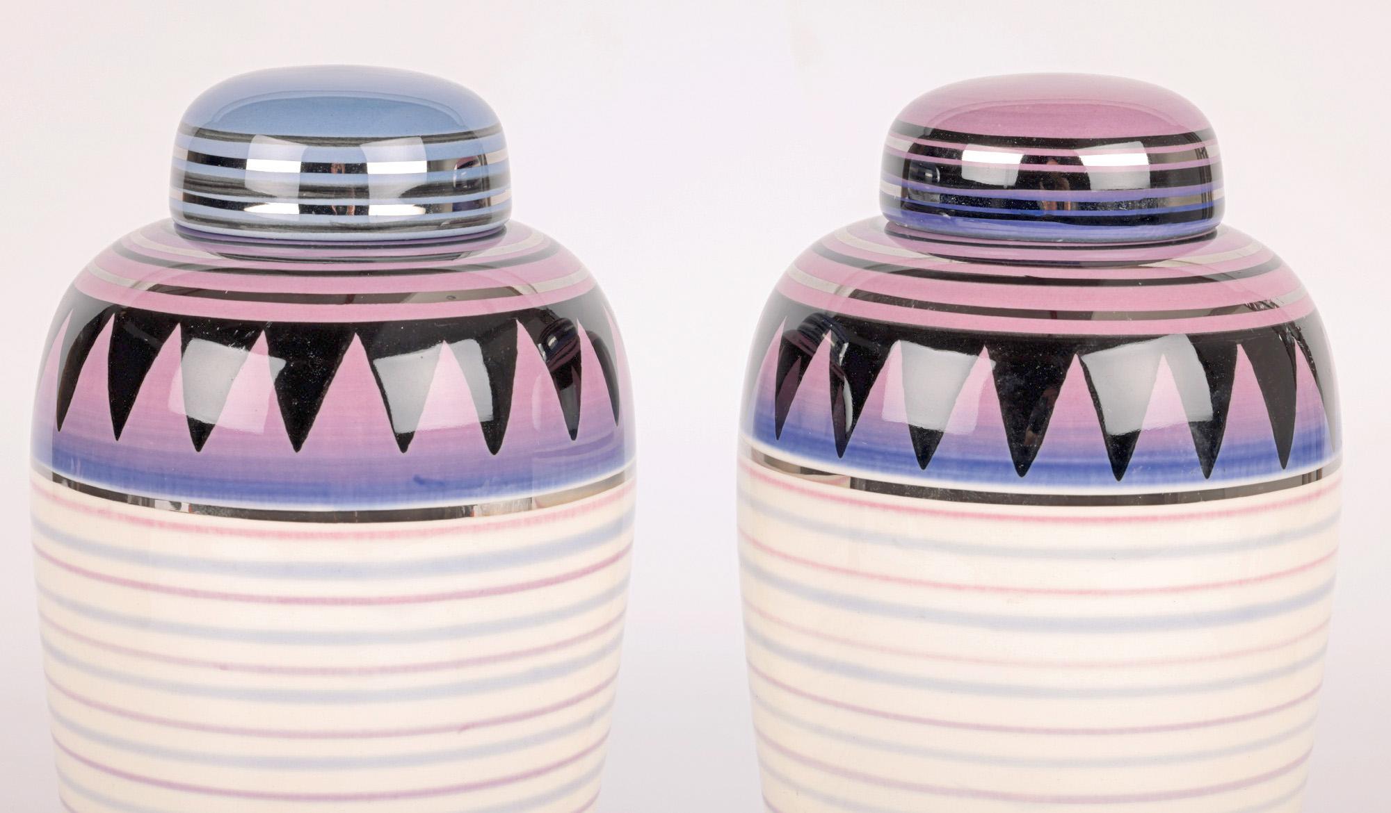 A very stylish pair Moorland Pottery ceramic horizontal linear pattern lustre lidded vases by Jon Plant and Adrian Tinsley and dated 1999. 

Moorland Pottery is based at Chelsea Works in Burslem and was founded in 1960 and is renowned for the