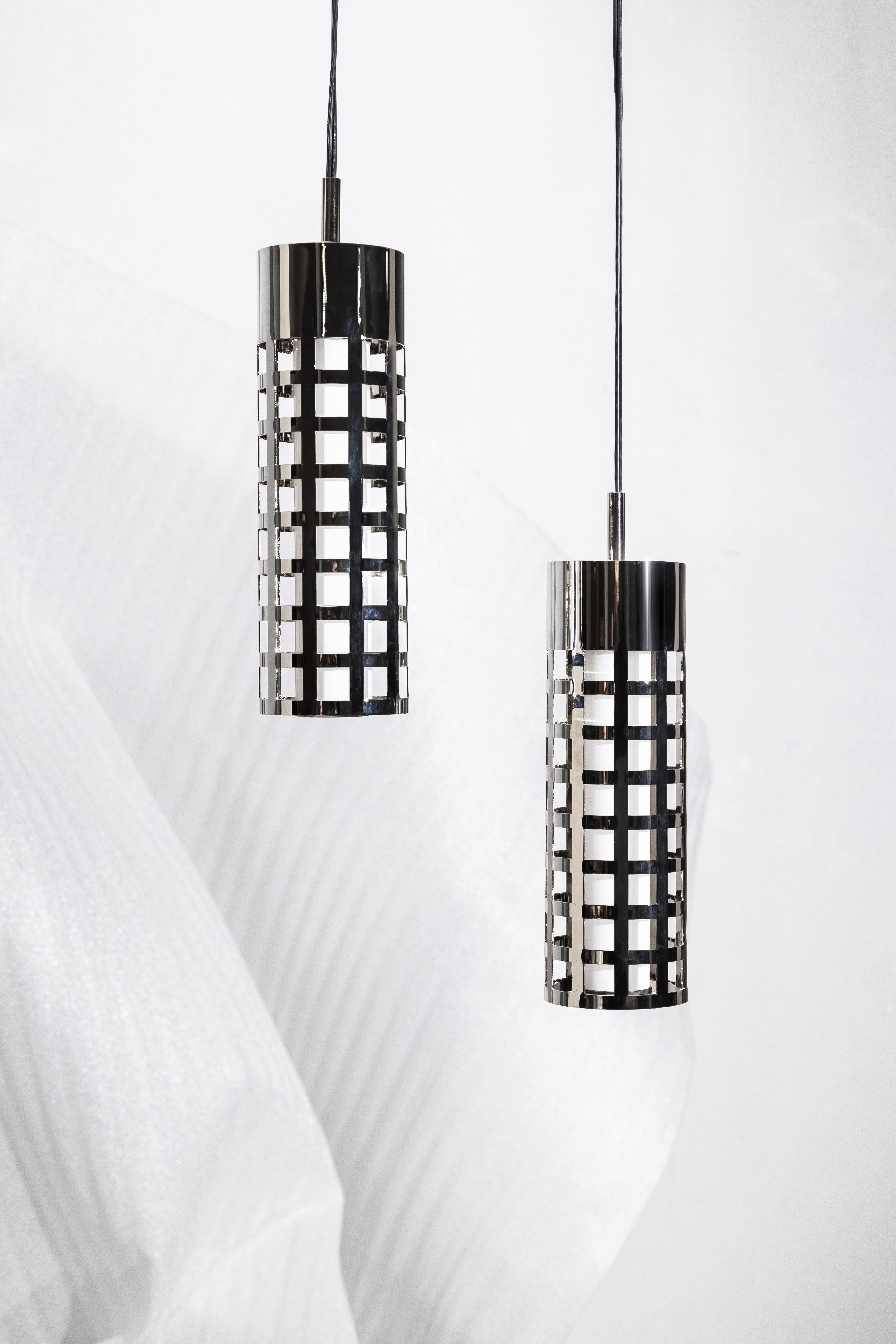STANDING STEEL, an objet d’art. Meticulously crafted from polished nickel, this pendant is a symphony of shapes, capturing the essence of industrial chic. Each element has been carefully considered and crafted, resulting in a complex and captivating