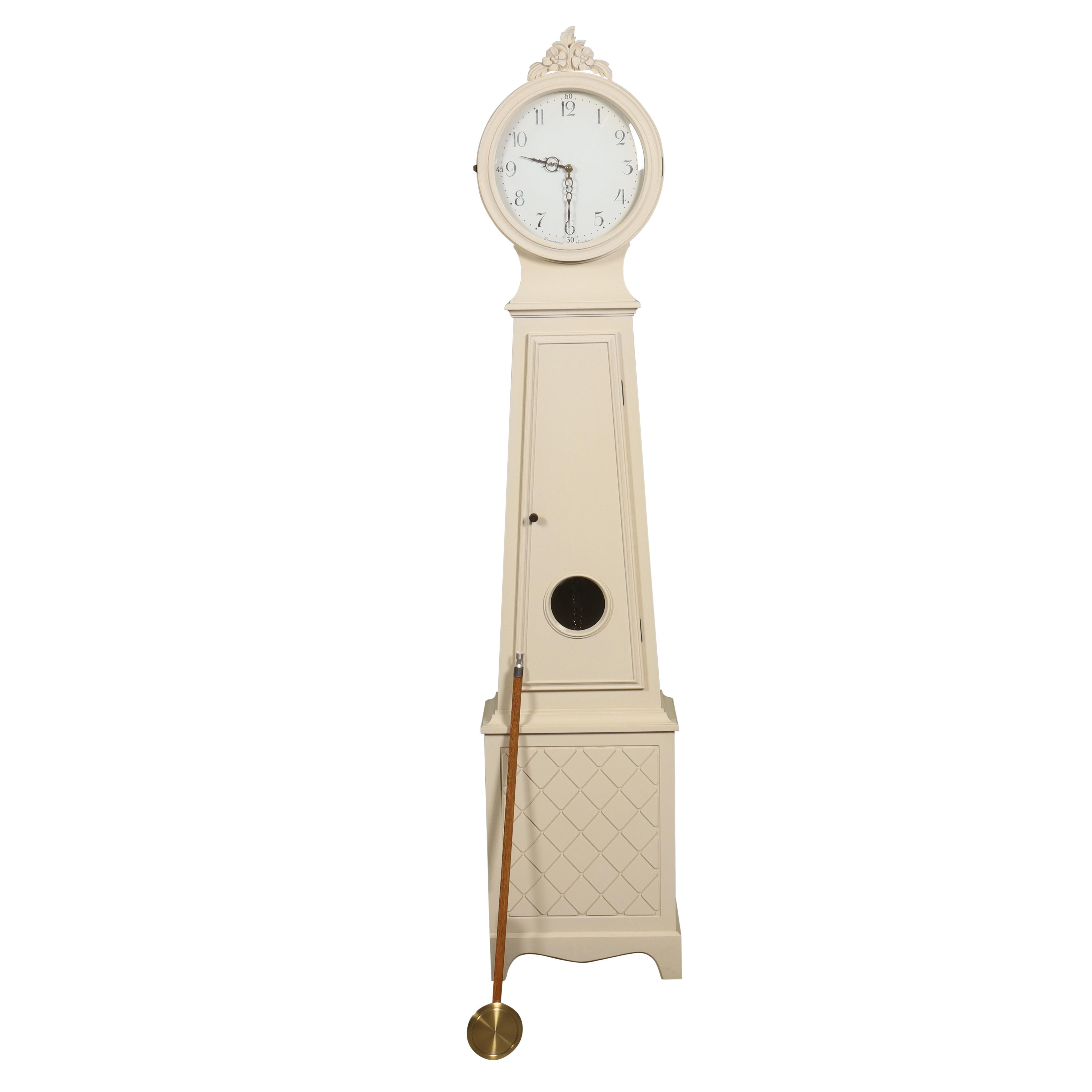 A classic Mora Clock made in the 1960s in white/cream with carved parts. This Mora Clock has a longcase clock mechanism of 2 weights and a pendulum and chimes on the hour and has one chime on the half hour. 

Width: 50cm / 19.7