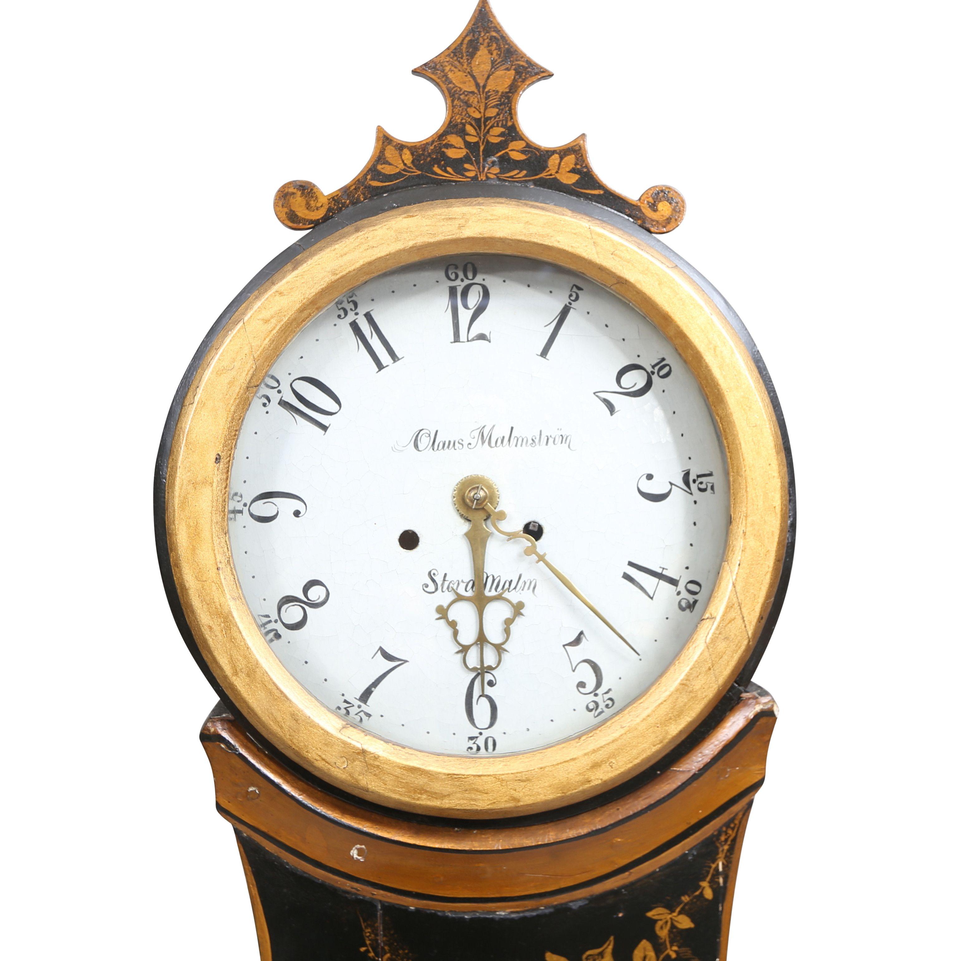1800's Swedish Mora clock with hand painted chinoiserie gold detailsing against a black painted background (original paintwork). Carved detailing of crown. Dial details include the name of the clockmaker: Olaus Malstrom and village Stora Malm.