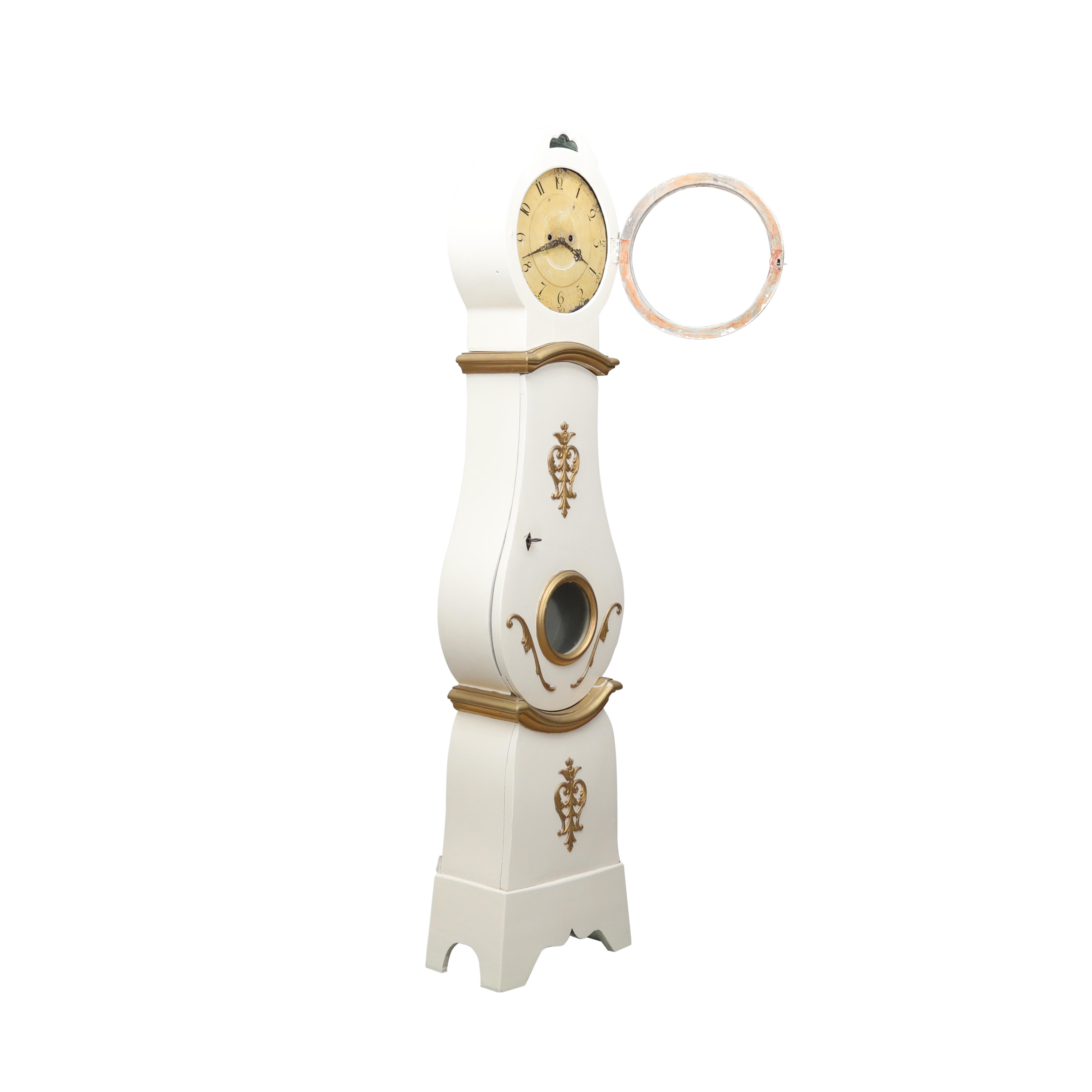 Antique Swedish Mora clock from the 1800's. Original paint; cream with gold detailing. Working Longcase clock mechanism of pendulum and 2 weights and a bell chime on the hour.

Width:42cm / 16.5