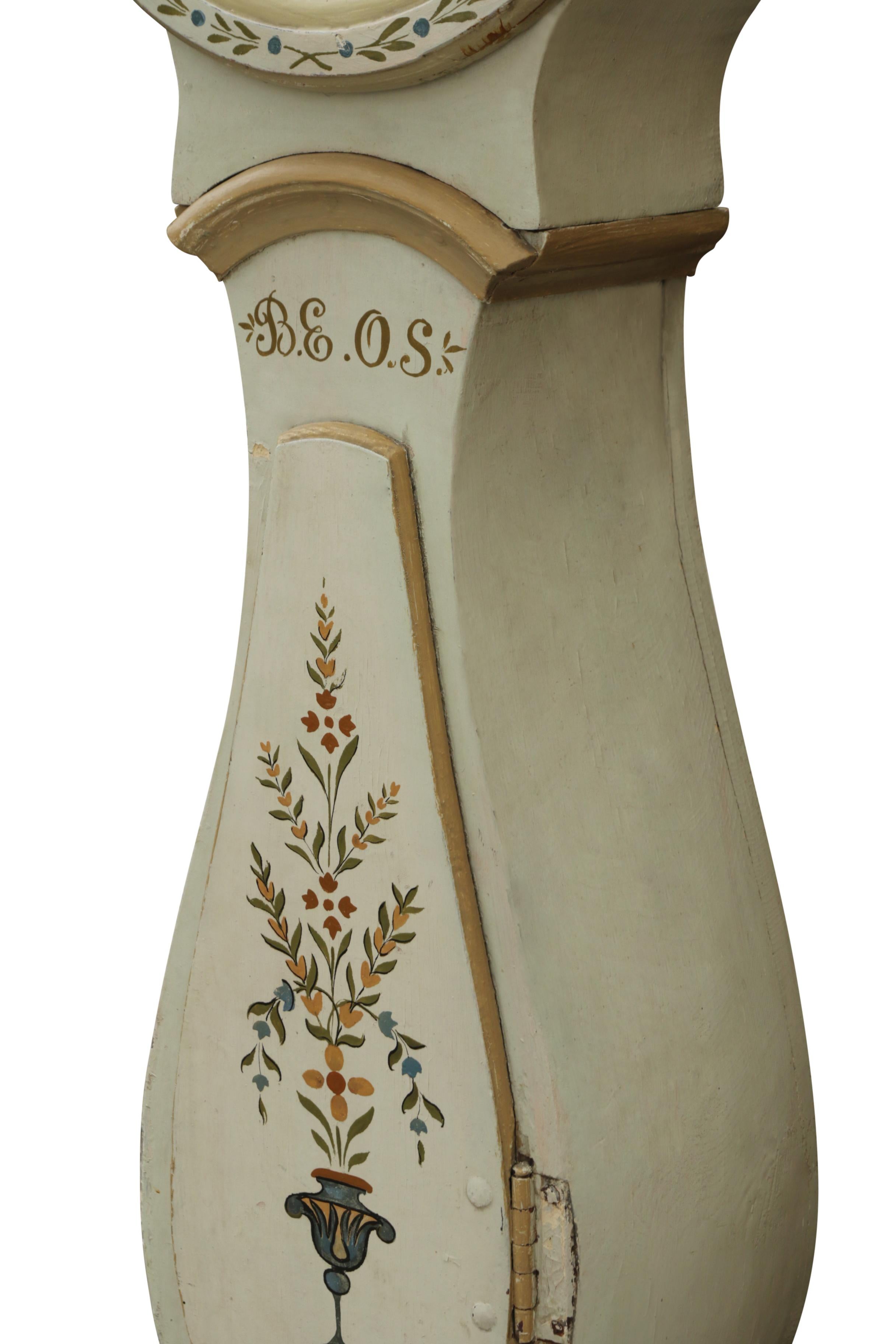 Swedish Mora clock with hand painted decorative floral details and clockmakers initials BEOS. Working Longcase clock mechanism of pendulum and 2 weights and a bell chime on the hour.

Width: 54cm / 21.3