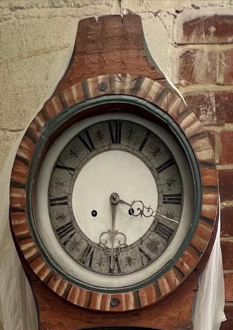 Antique Swedish mora clock from C. 1844 in rare faux wood grain Kurbitz folk art finish finish and a superb rare detailed metal face roman numeral face in generally good condition for its age . Measures: approx 200 cm.

It has the Classic extended
