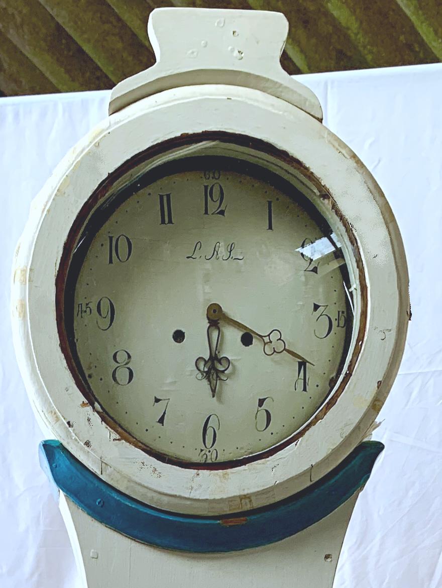 Swedish country Mora clock from early 1800s in white paint finish and blue detail with a Classic shape body and a good face with lots of detail and nicely detailed hood in good condition. Measures: 204cm.

It has the Classic extended belly of a