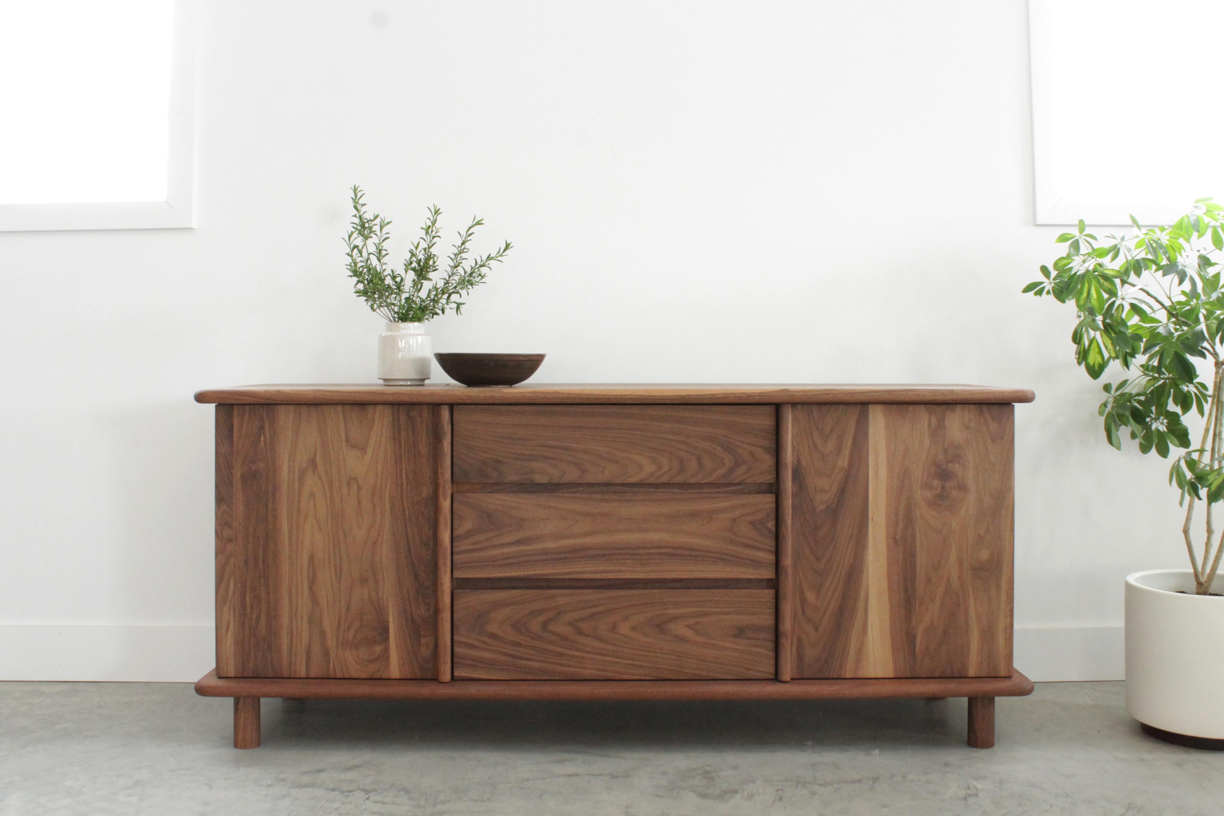 The Mora credenza is as functional as it is sculptural. Doors with robust vertical pulls conceal adjustable shelving and allow space for media storage or other items. Each surface boasts it’s own unique yet consistent graining and soft edges. Built