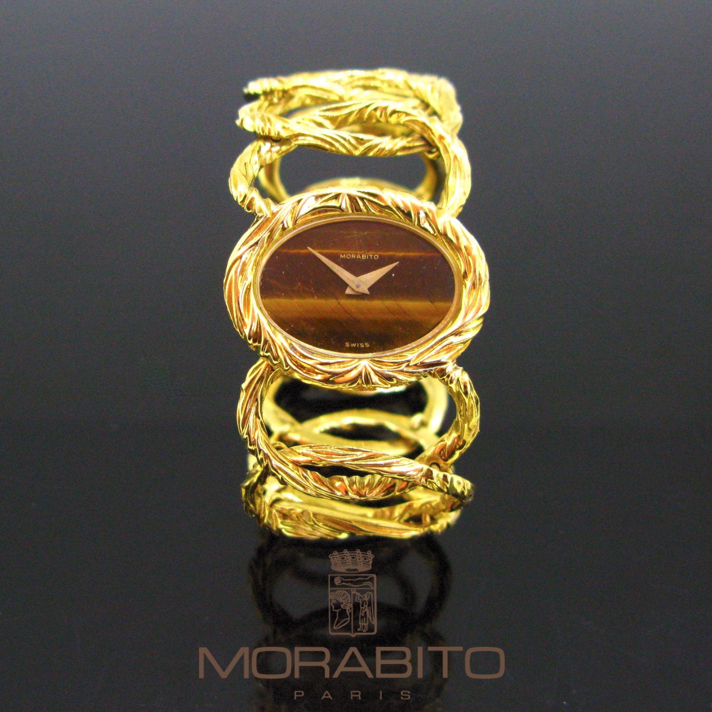 This Morabito watch is fully made in 18kt yellow gold. The case is oval and set with a tiger-eye. The bracelet comprises 12 oval textured gold links. It is a manual wind wristwatch. It is in good vintage condition. Pascal MORABITO is a famous French