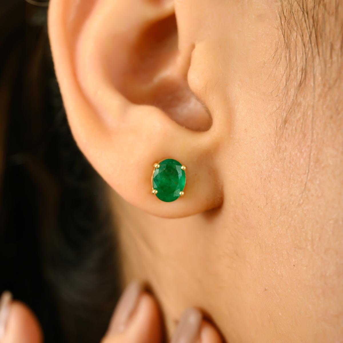 Intemporelles et vibrantes, ces boucles d'oreilles classiques sont réalisées en or jaune 14 carats et mettent en valeur deux émeraudes ovales captivantes d'un poids total de 2,41 carats. Serties dans une monture simple à quatre griffes, les