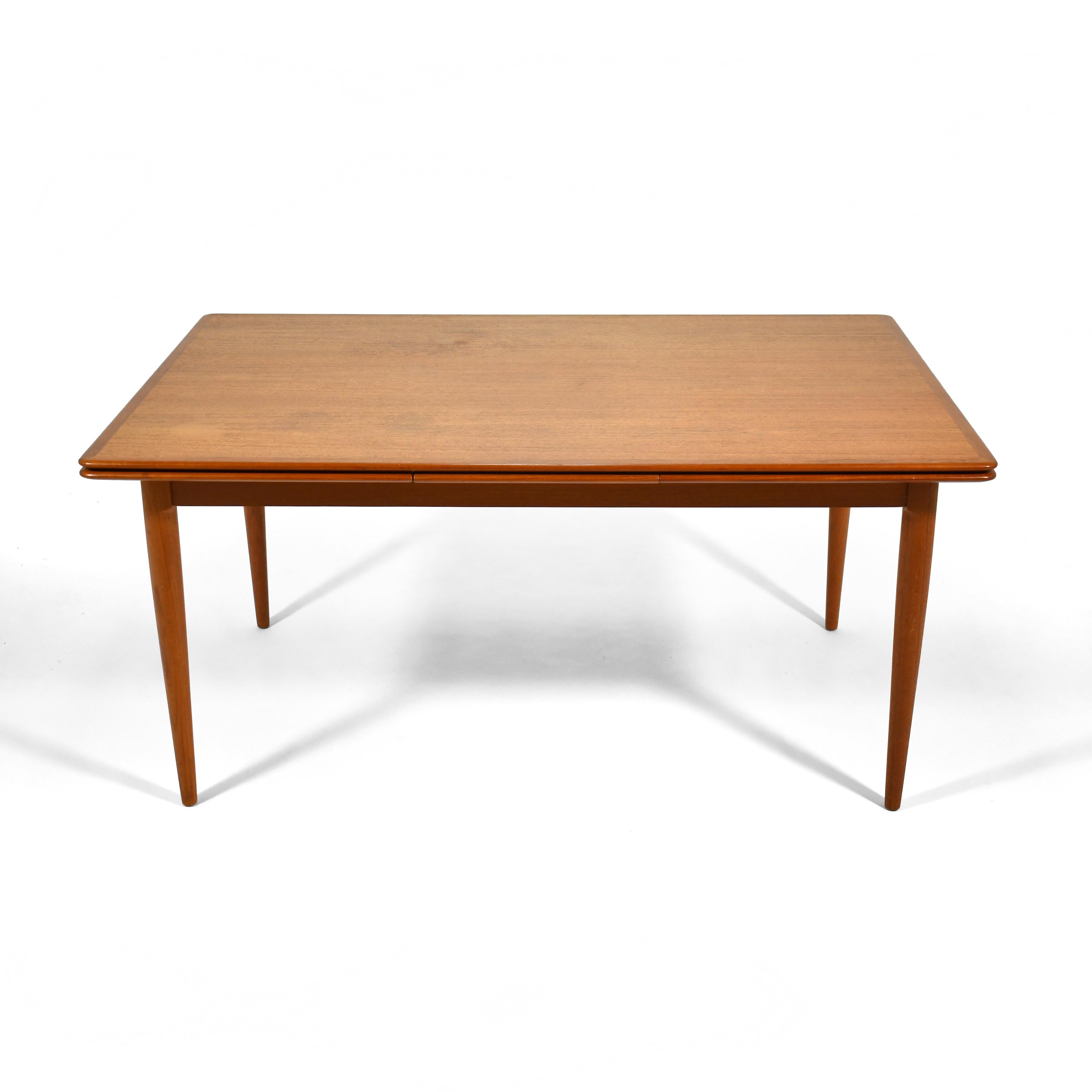 This teak dining table by Moreddi is a Danish design classic. Beautifully detailed and constructed, the versatile table has two leaves which slide smoothly from underneath the top, expanding the length by over 43