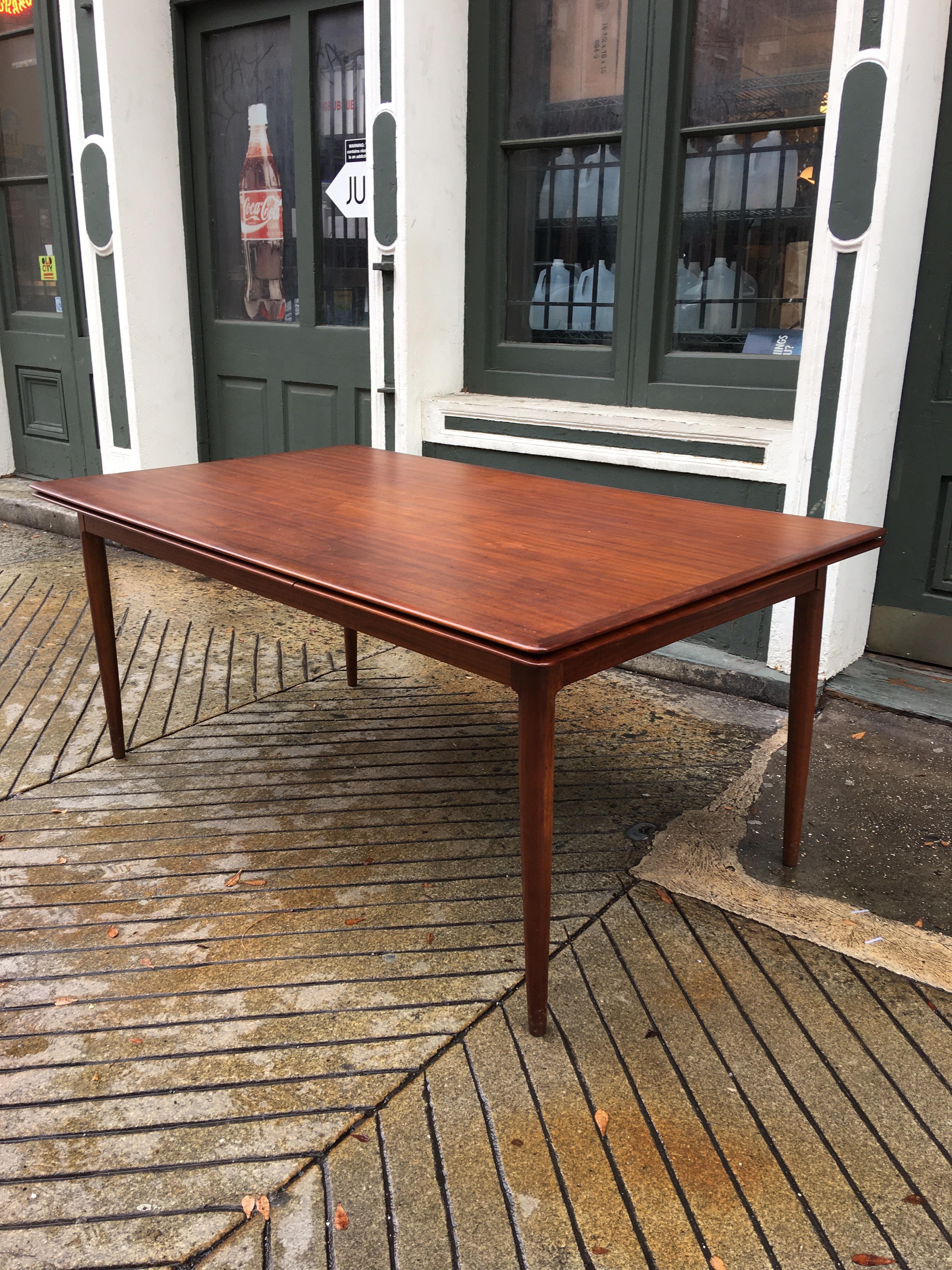 Moreddi teak dining table with 2 pull out / pull-out leaves. Table retains its original finish and is in great shape! Shows minimal surface scratches. Pull out / pull-out leaves are slightly lighter in color from being stored away most of the time!