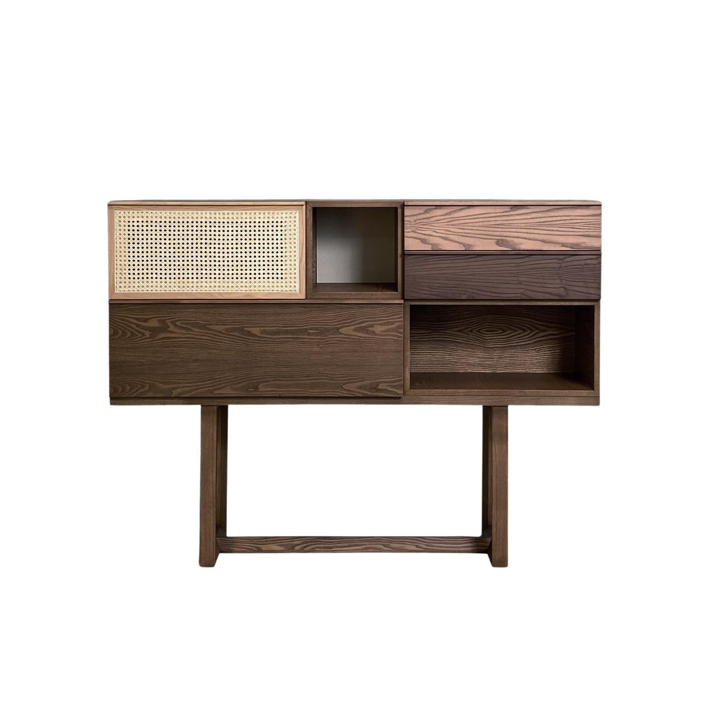 Table console en frêne formée de 2 modules avec porte à ouverture vasistas, 2 modules ouverts et 2 tiroirs placés en haut à droite. Pied en bois de frêne massif. Porte à ouverture vasistas proposée avec couverture en paille de Vienne, sur demande