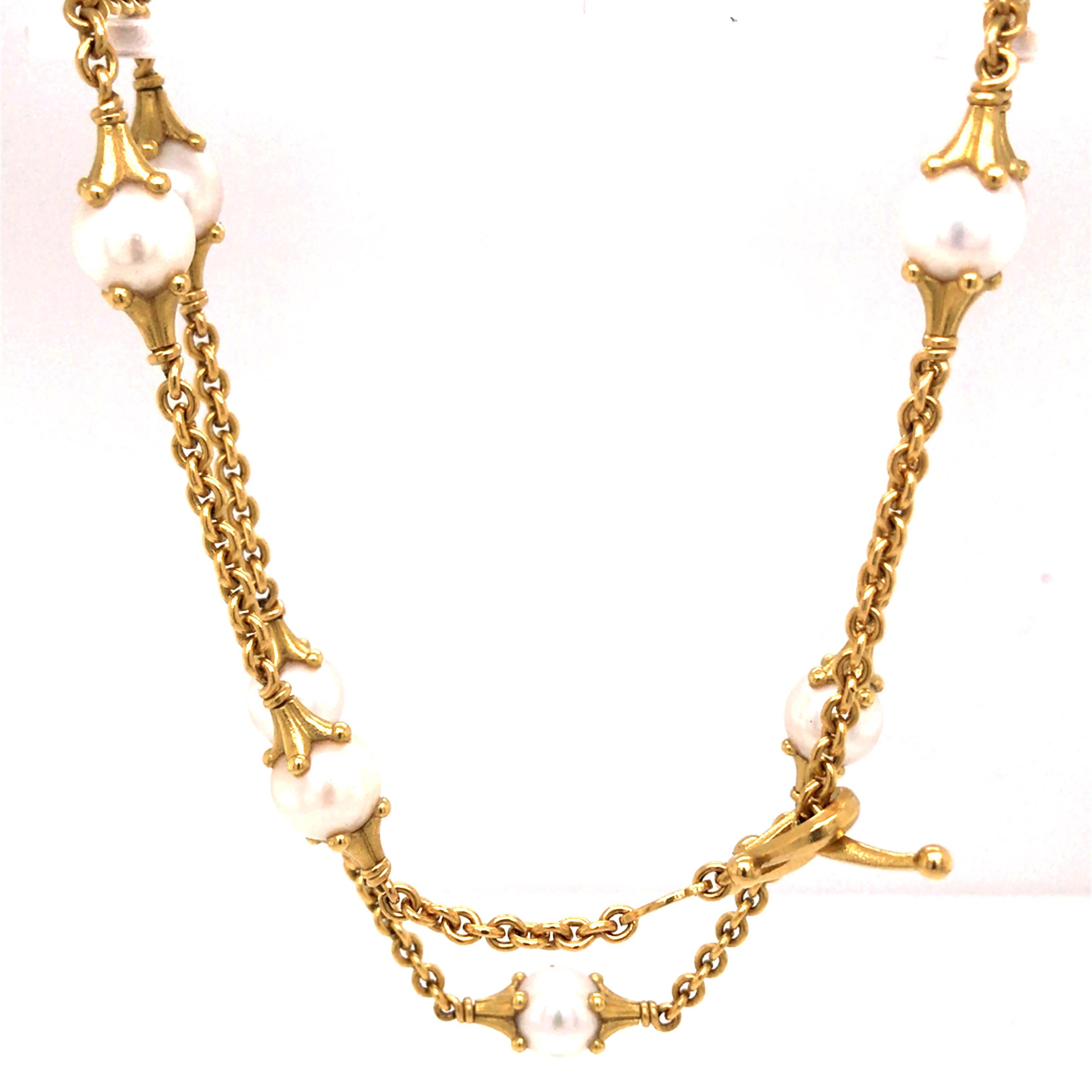 Morelli 18K Yellow Gold Pearl Station Necklace. (8) White Pearls are expertly set. The Necklace measures 16 inch in length. 29.39 grams. Toggle Closure. Signed.