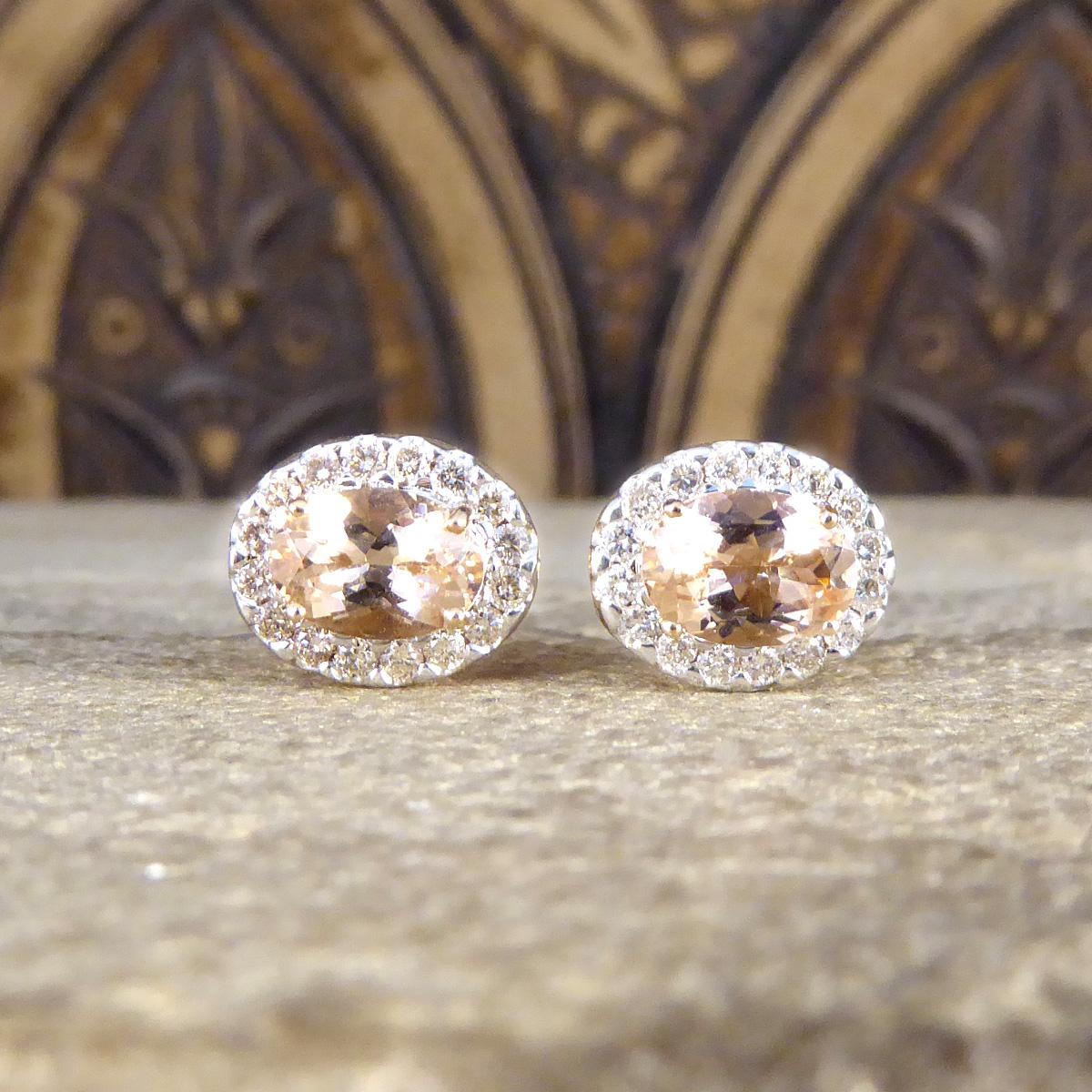 A perfect pair of pink and sparkly cluster earrings. These beautifully romantic earrings each hold Morganite with a lovely pink hue in a four claw setting. They both have a surround of 16 smaller brilliant cut Diamonds that have a warm feel to