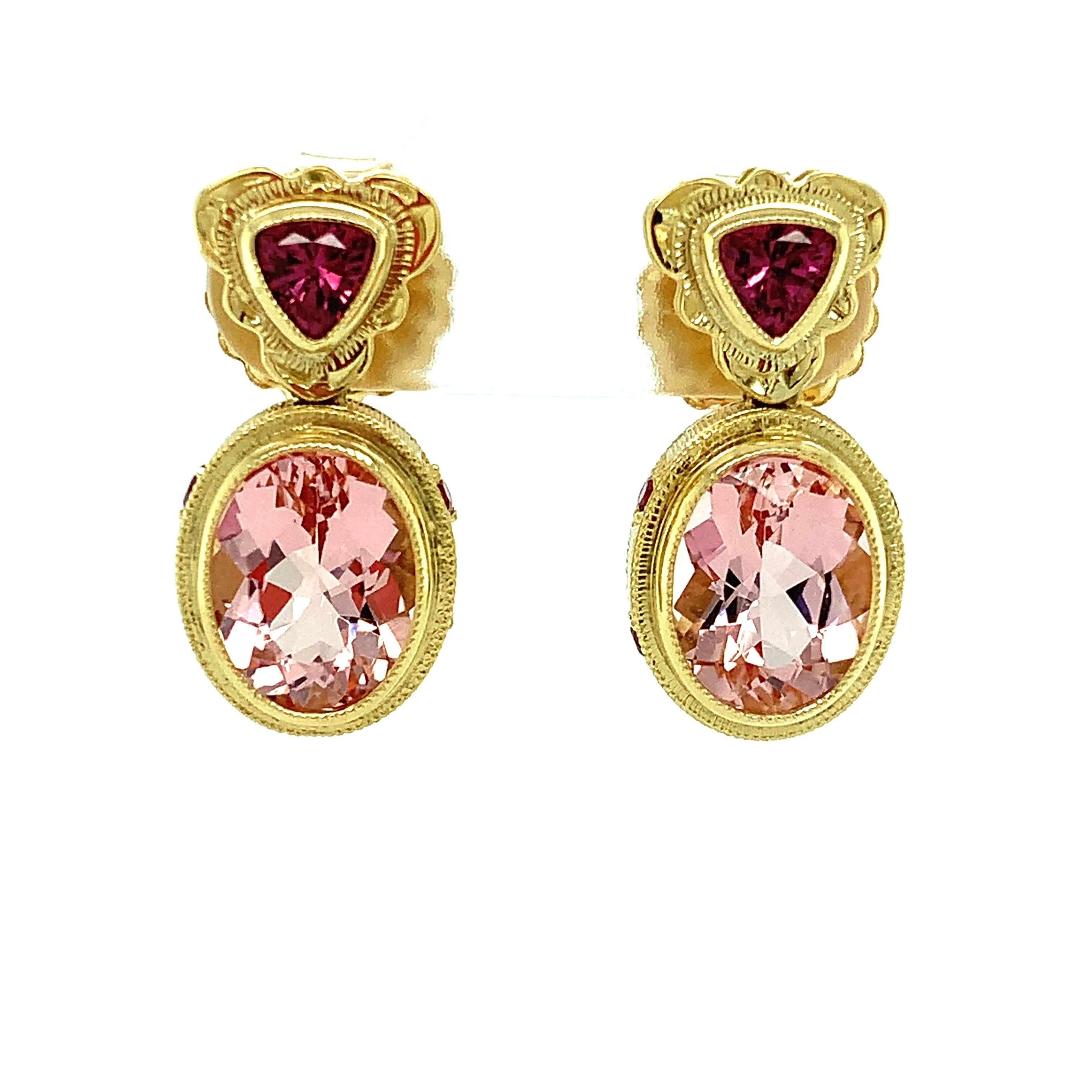 These exquisite dangling earrings feature stunning pink morganites set in handmade 18k yellow gold bezels accented with rose-colored rhodolite garnets. Morganite belongs to the same mineral family as aquamarine and emerald, and refers to the pink