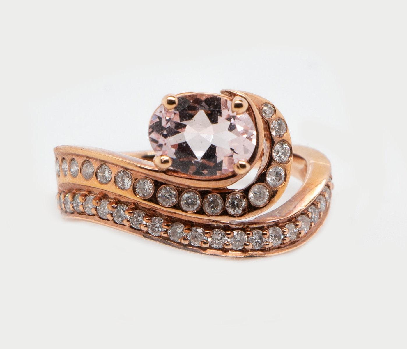 This is a magnificent natural morganite and diamond halo ring set in solid 14K rose gold. The natural and large 8X6MM 1.14Ct Morganite oval has an excellent peachy pink color (AAA quality gem) and is set on top of a curved diamond-encrusted shank