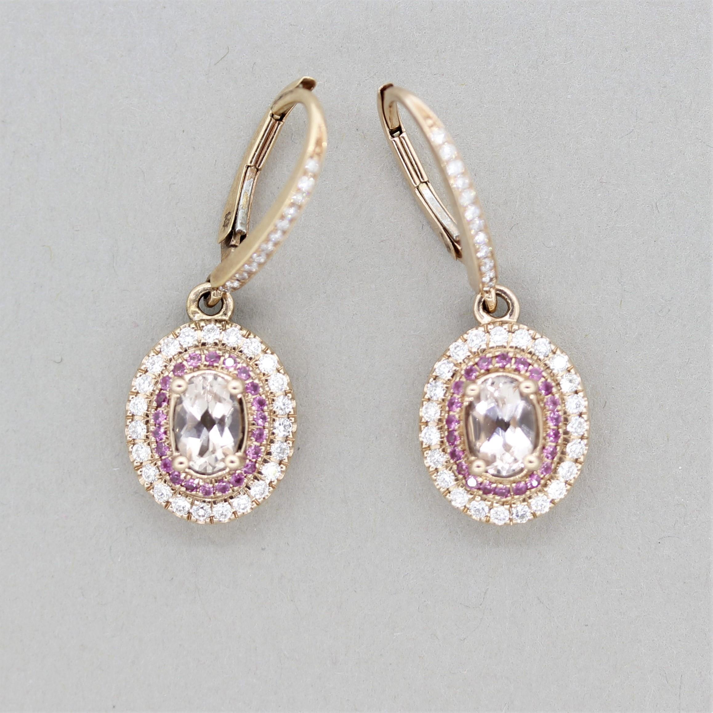 A cute and stylish pair of earrings featuring oval-shaped morganites weighing 1.00 carat. They are accented by halos of diamonds, 0.60 carats, and pink sapphires, 0.25 carats, which adds a unique style to the drops. Made in 14k rose gold.

Length: