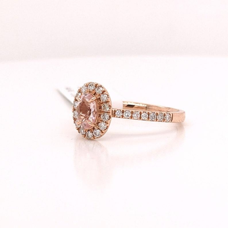 This dainty ring features a pretty Pink Morganite in 14k Rose Gold with a classic Diamond halo and pave Diamond shank. A timeless ring design perfect for an eye catching engagement or anniversary. This ring also makes a beautiful birthstone ring for