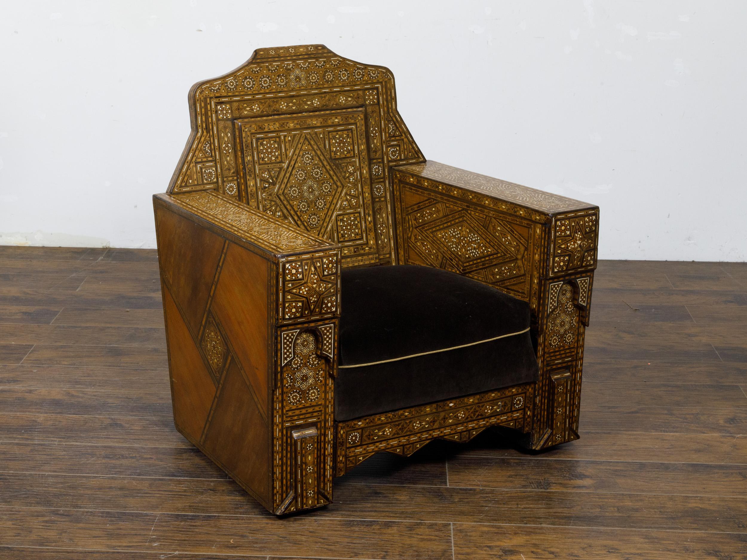 An Moroccan club chair from circa 1900 with abundant geometric bone inlay and custom cushion. This Moroccan club chair, hailing from the early 20th century, is a masterpiece of craftsmanship and aesthetic appeal, featuring an opulent geometric bone