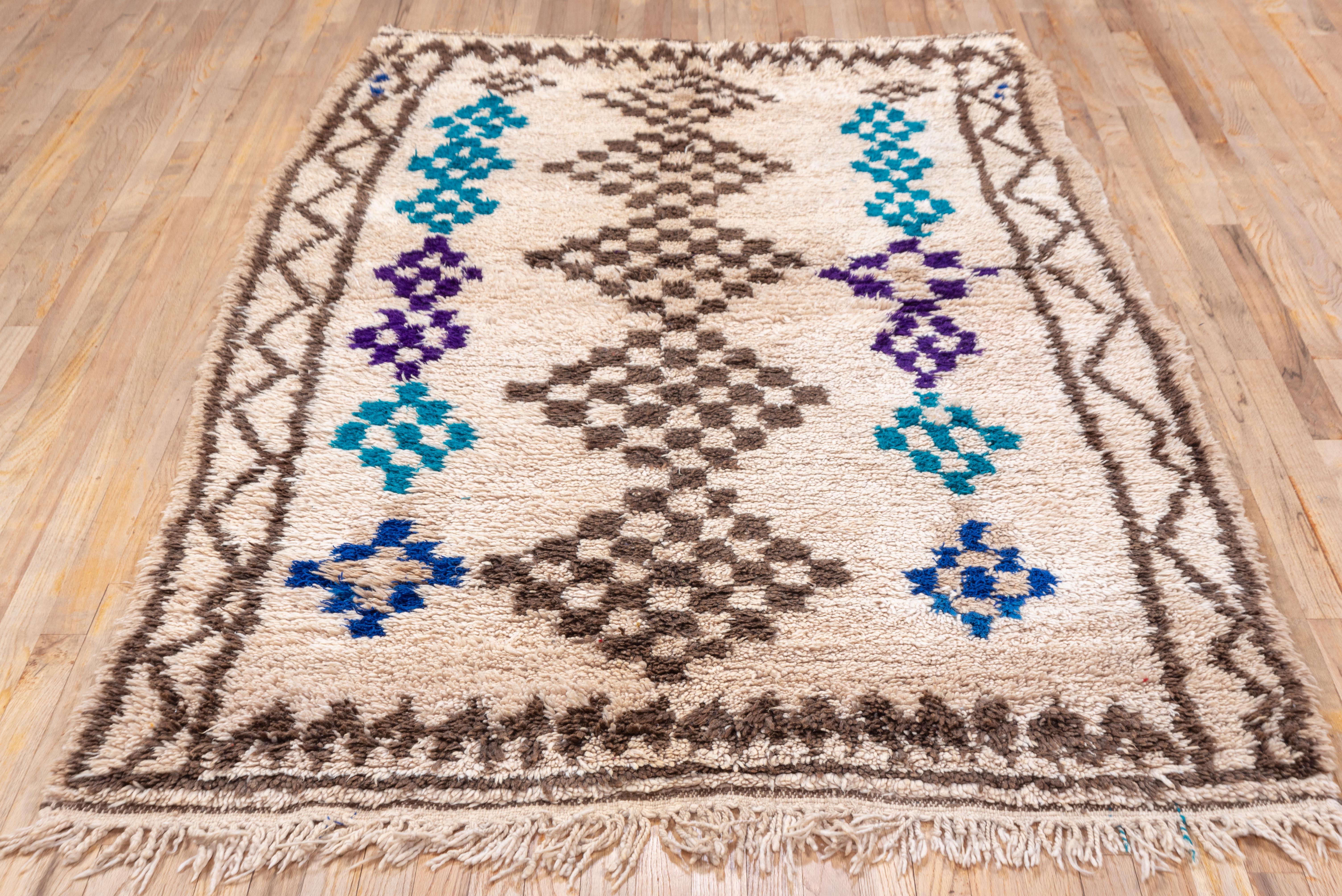 Gorgeous Moroccan tribal village rug in abstract, colorful design in purple navy and teal with a cream field. 