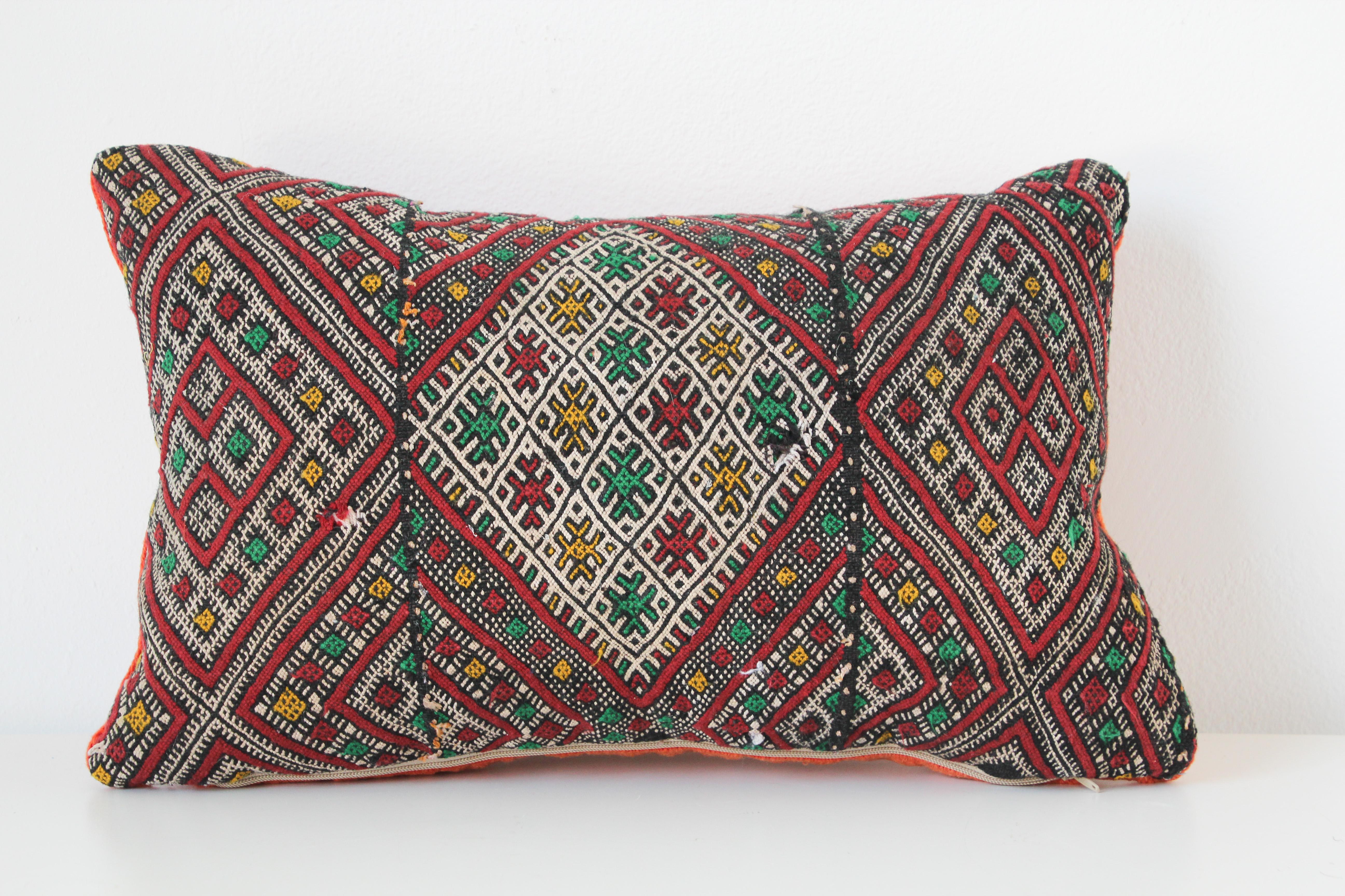 Moroccan Berber handwoven tribal throw pillow made from a vintage rug.
The front and the back are made from a different rug, front is more elaborate and back is more plain.
Geometric African tribal designs in red, white and black and some green