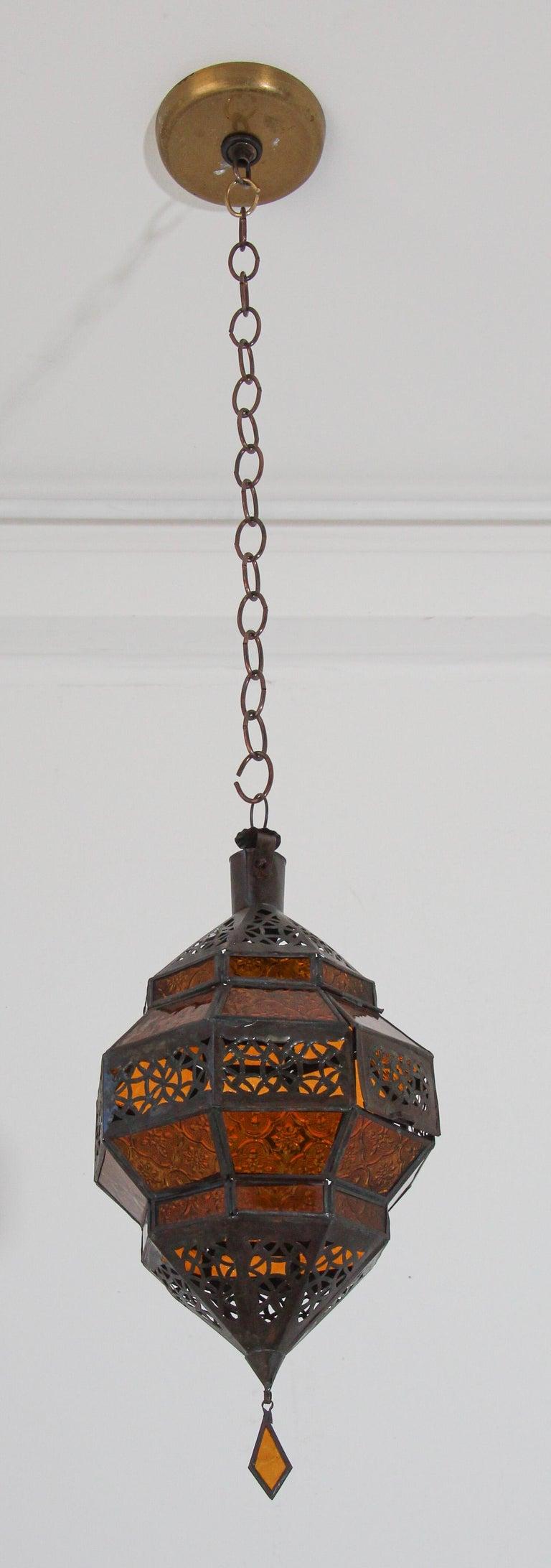 Moroccan metal and amber glass lantern in diamond shape.
Moroccan lantern in octagonal shape with rust color metal finish and amber glass.
The top and bottom hand-cut openwork metal with Moorish design.
This Moroccan lantern when lit will cast light