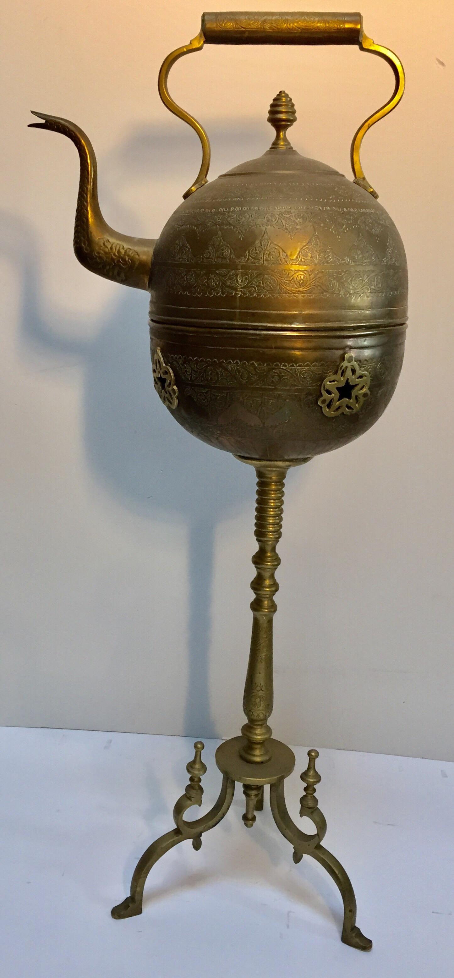 Moroccan antique brass tea kettle pot with warmer on stand.
Museum quality, one of a kind antique artistically and delicately handcrafted tea water pot.
Solid brass, hand hammered, chased, engraved with floral and geometric designs.
The brass