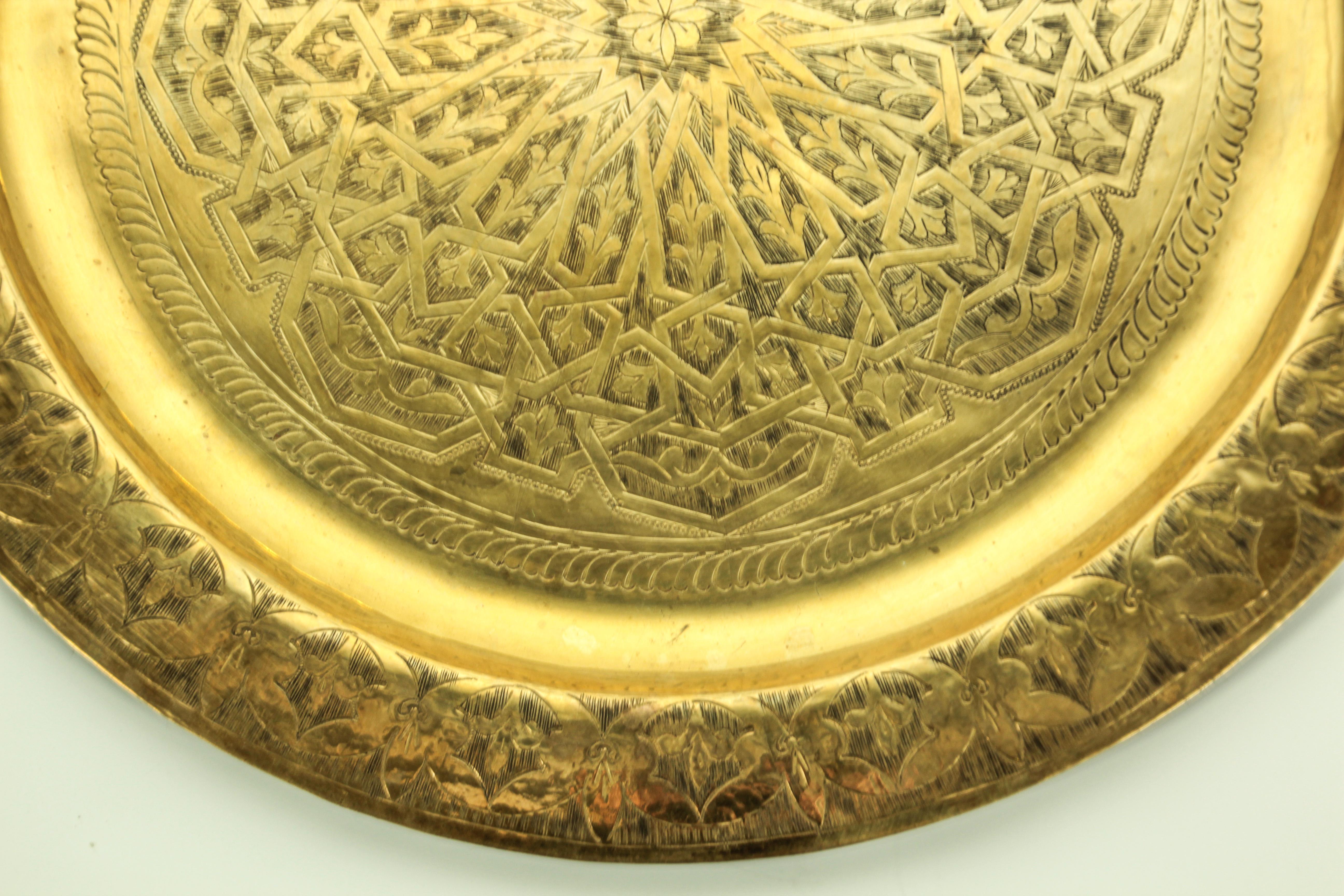 Moroccan antique round brass tray.
The handcrafted circular brass platter is decorated and hammered with geometric Moorish designs.
Metal brass with very fine hand chased floral and geometric and floral stylized Arabic designs.
Measures: Diameter