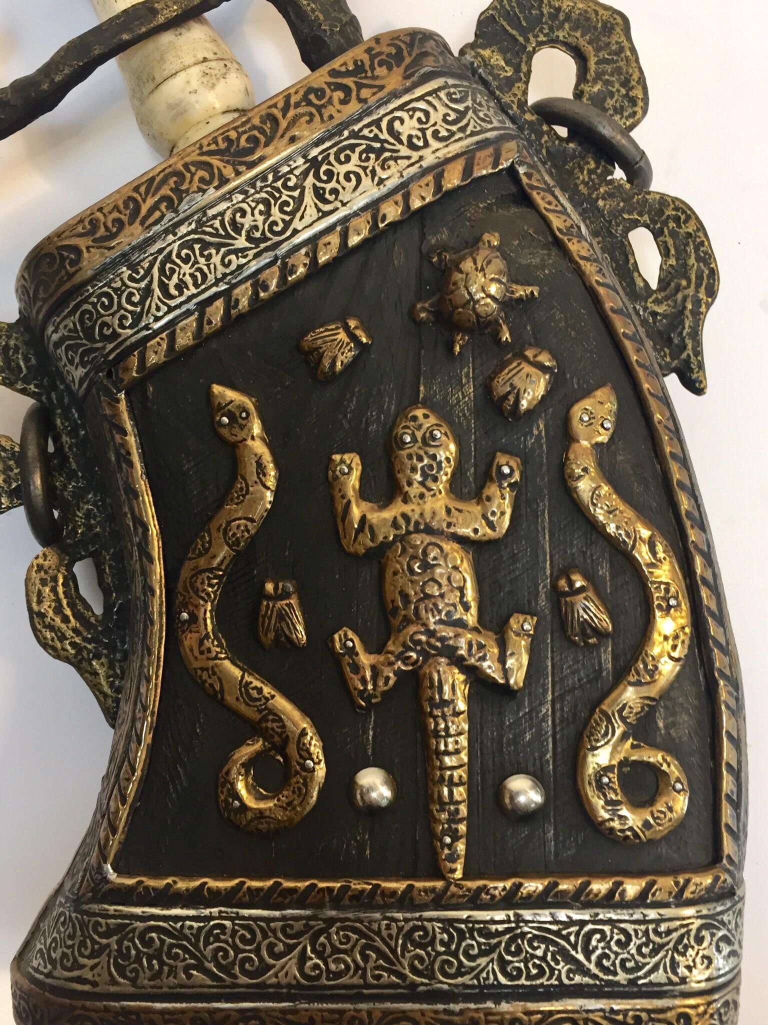 Moroccan antique tribal gun powder case flask, wood covered with brass and silver filigree, delicately hand-hammered brass with animals decor for power protection, the top open and the neck is made of bone.
Size: 11
