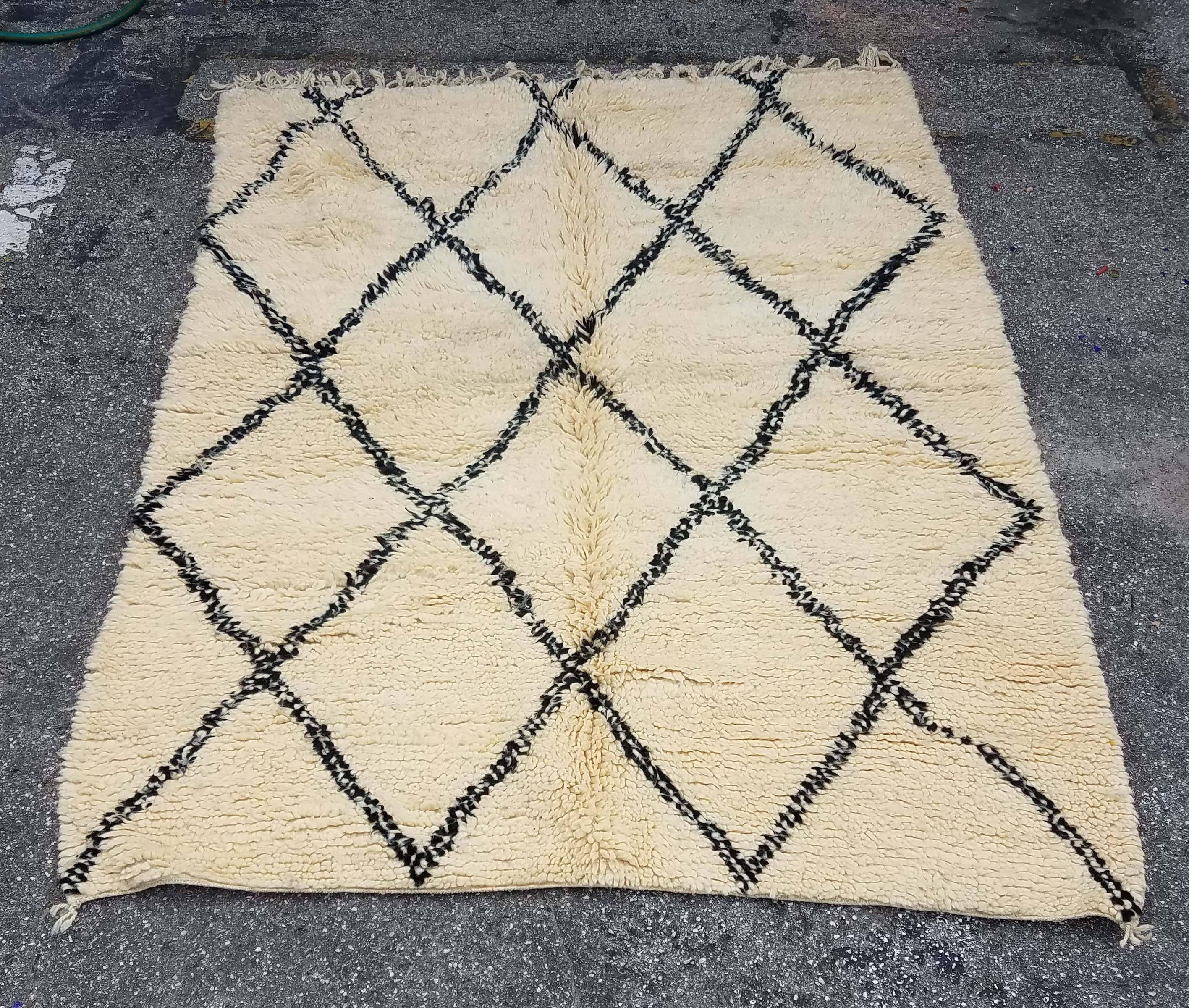 Moroccan black / white Beni Ourain rug. Made of pure wool. Excellent handcraftsmanship. Priced to sell. Measuring approximately 7 feet long and 5 feet wide, this amazing rug from the Atlas mountains of Morocco will be a great addition to your home