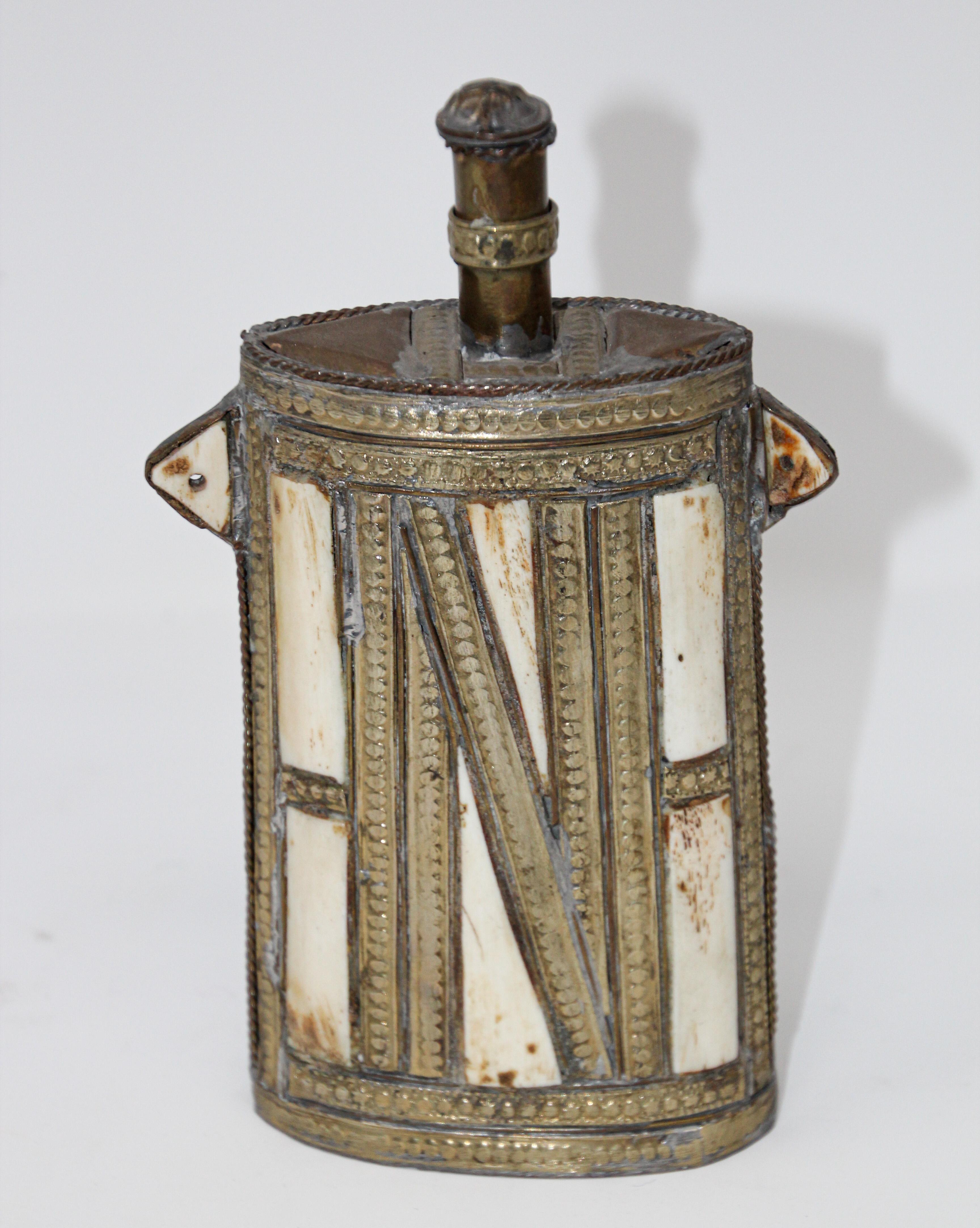 Great decorative Moroccan Berber Tuareg metal brass powder flask. African decorative brass with front richly decorated with Moorish embossed brass ocverlay. Moroccan tribal powder flasks, the valve stem turns and open. Truly a conversation museum