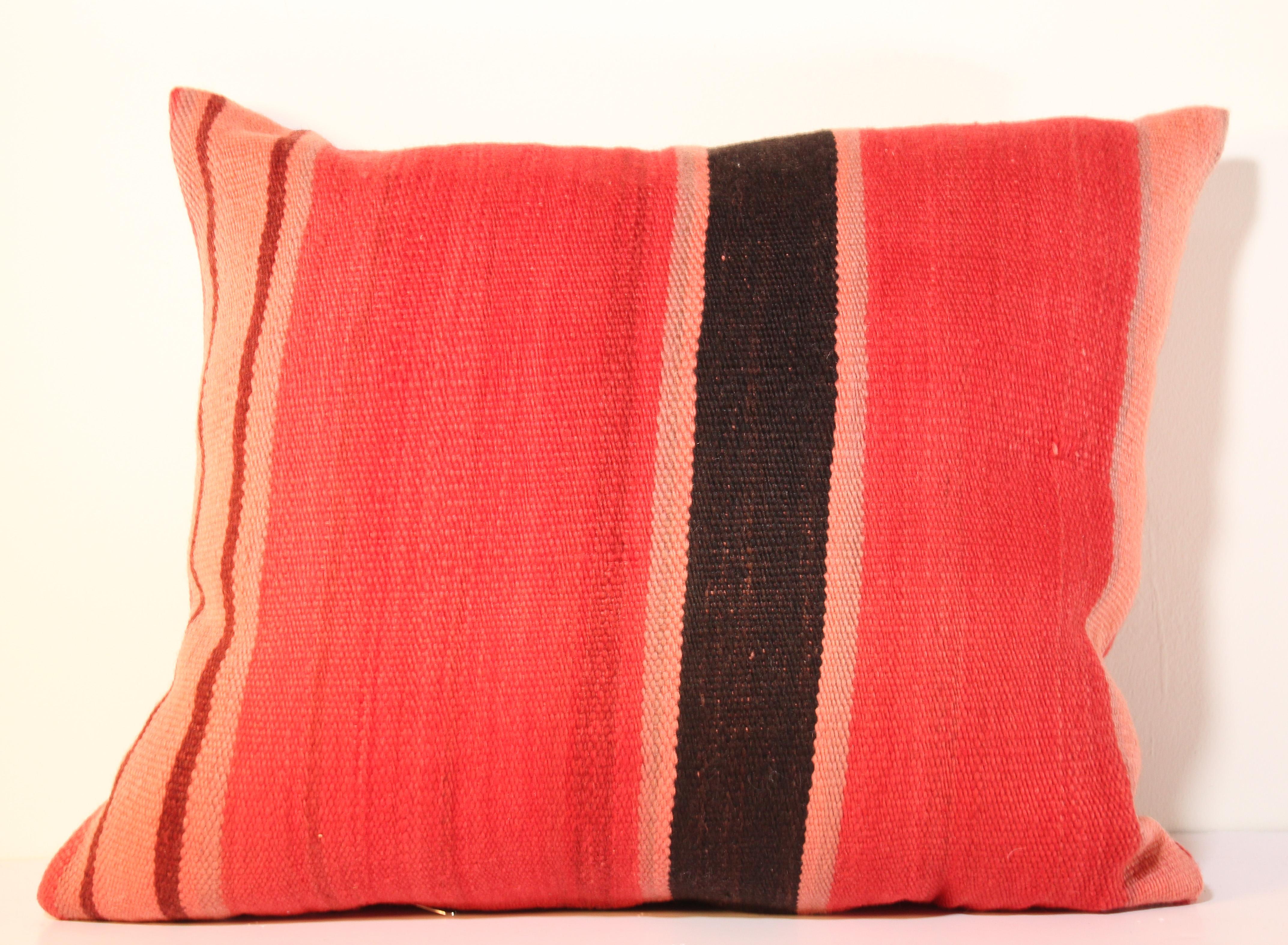 Custom Berber pillow cut from a vintage handwoven wool Moroccan tribal flat-weave Kilim tribal rug.
Handwoven by the Berber women from the Atlas Mountains of Morocco. 
Great handcrafted textile with earth tone colors large stripes in purple,