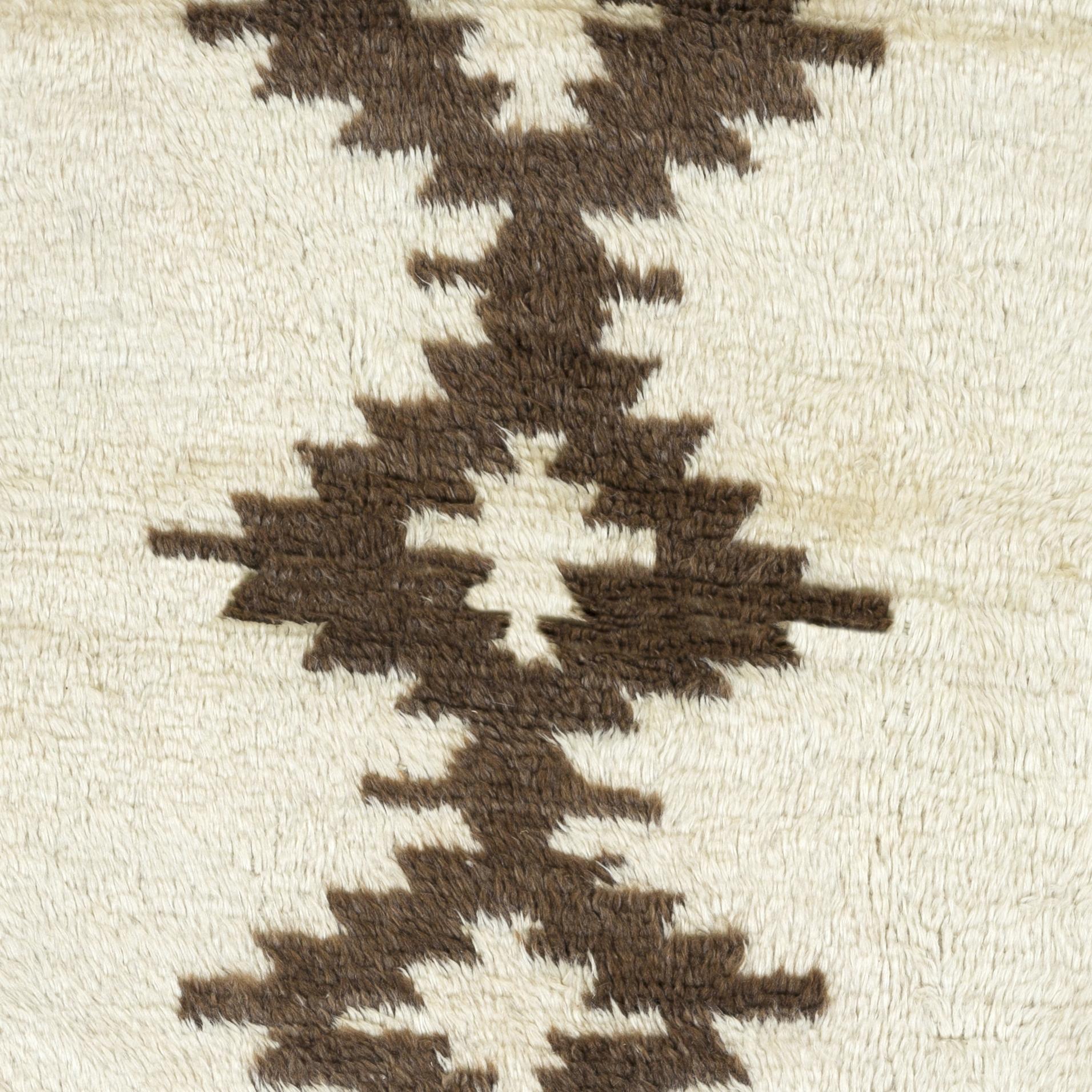 Transforma tu espacio con el discreto lujo de nuestra alfombra Tulu de estilo marroquí anudada a mano, inspirada en los diseños ricos en patrimonio de las tribus Beni Ourain. Esta alfombra es una celebración de la artesanía y la tradición, hecha