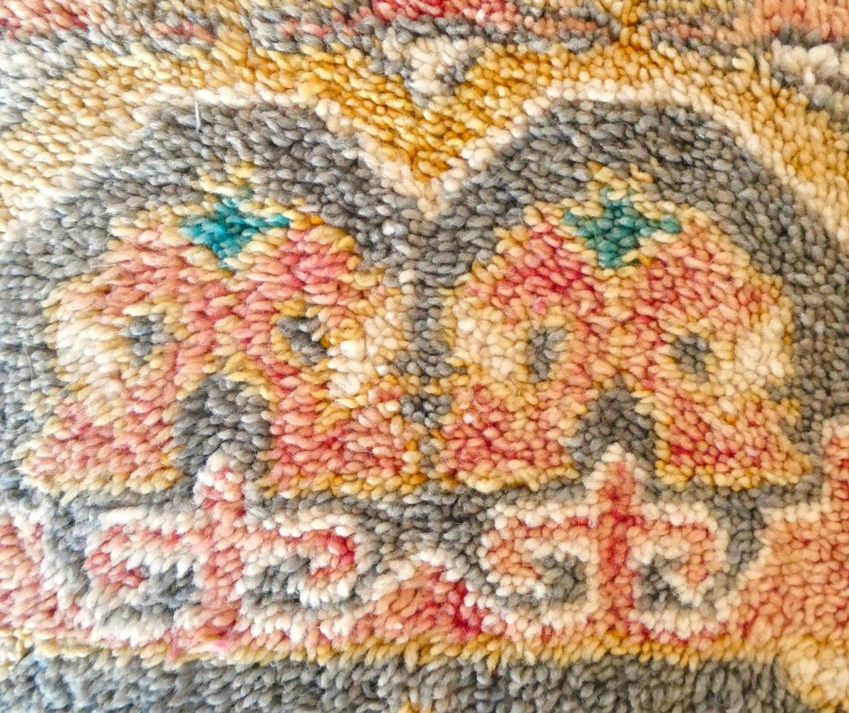 Puf de suelo marroquí único en su especie, hecho de una. alfombra vintage de mediados de siglo tejida a mano en lana hilada a mano de color terracota, dorado y gris. Detalles artesanales de borlas y reverso de kilim de lana. Nuevo inserto