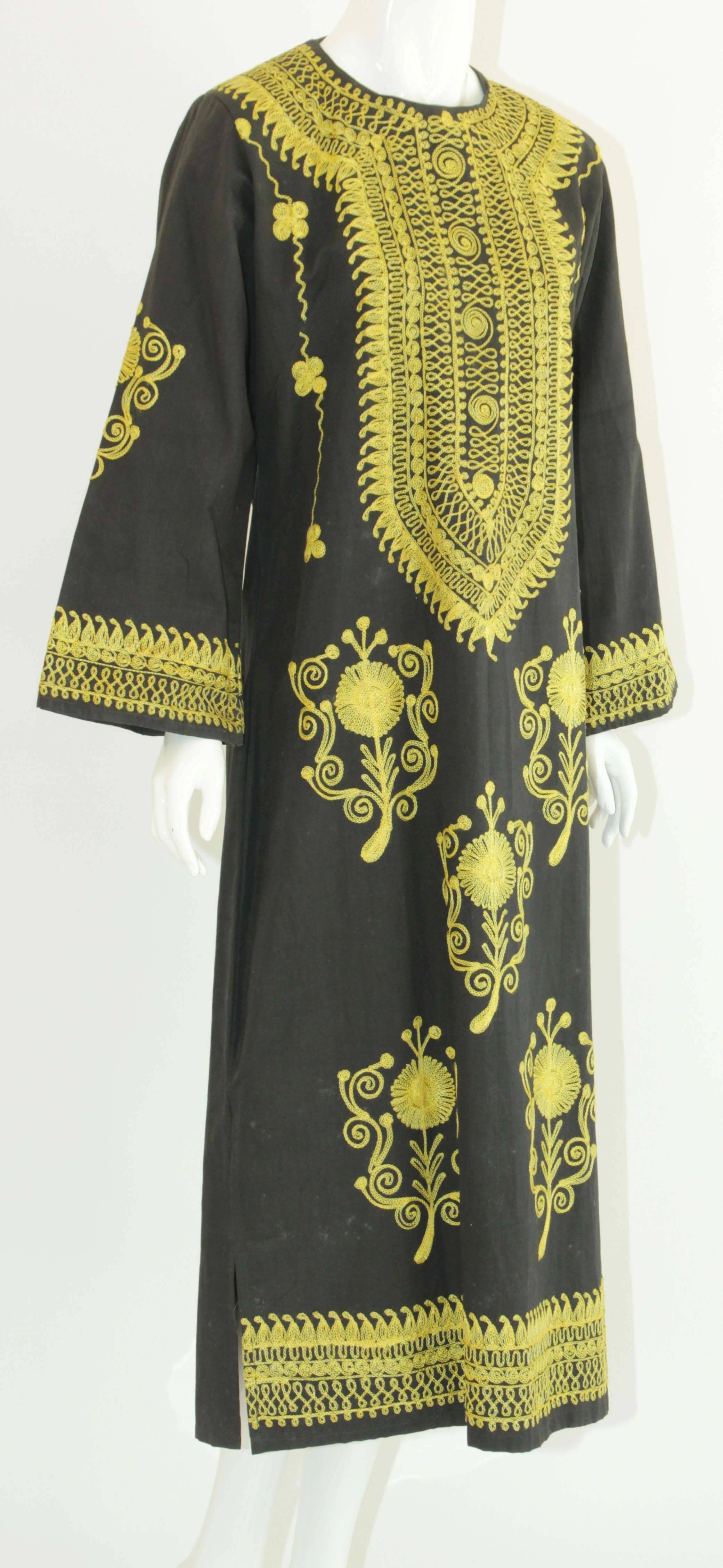 Vintage Moorish Middle Eastern Afghan Ethnic black caftan, circa 1970s.
Vintage Bohemian style long Dress kaftan. 
Side slits along the maxi dress keep things cool.
Nice embroidered in yellow gold threads.
Long sleeves.
Size medium.
Measurements: