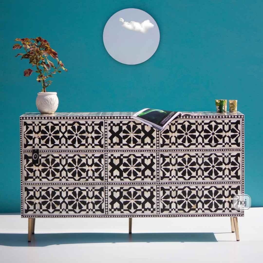 Eleva i tuoi interni con questo comò a nove cassetti con intarsio d'osso marocchino squisitamente artigianale, una straordinaria fusione di arte tradizionale e lusso moderno. Progettato e realizzato da maestri artigiani in India, questo comò
