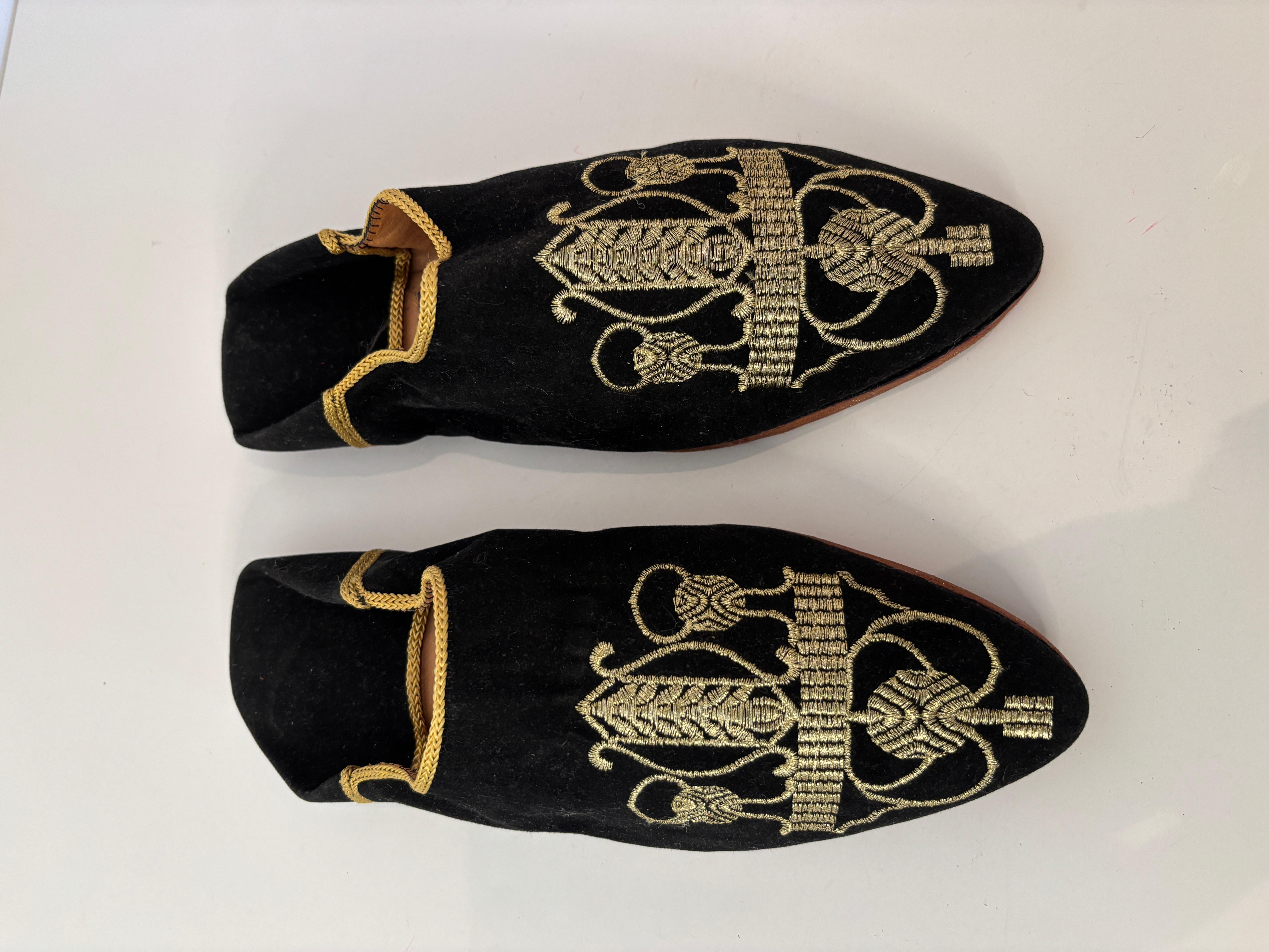 Vintage velours noir brodé bout pointu africain marocain chaussures mauresques.
Chaussons plats ethniques brodés d'Afrique du Nord, de style mauresque et moghol, en fil d'or métallisé.
Chaussures de cérémonie en velours pour mariage, décorées de