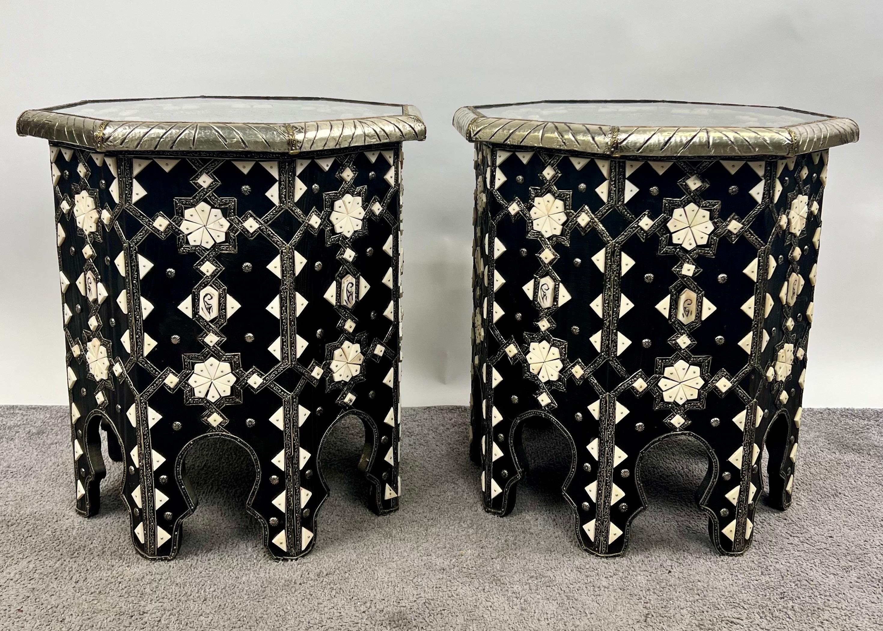 Este exquisito par de mesas auxiliares octogonales marroquíes desprende una elegancia atemporal, mostrando el arte de la artesanía morisca tradicional. Cada mesa está meticulosamente hecha a mano con una llamativa base de madera negra, adornada con