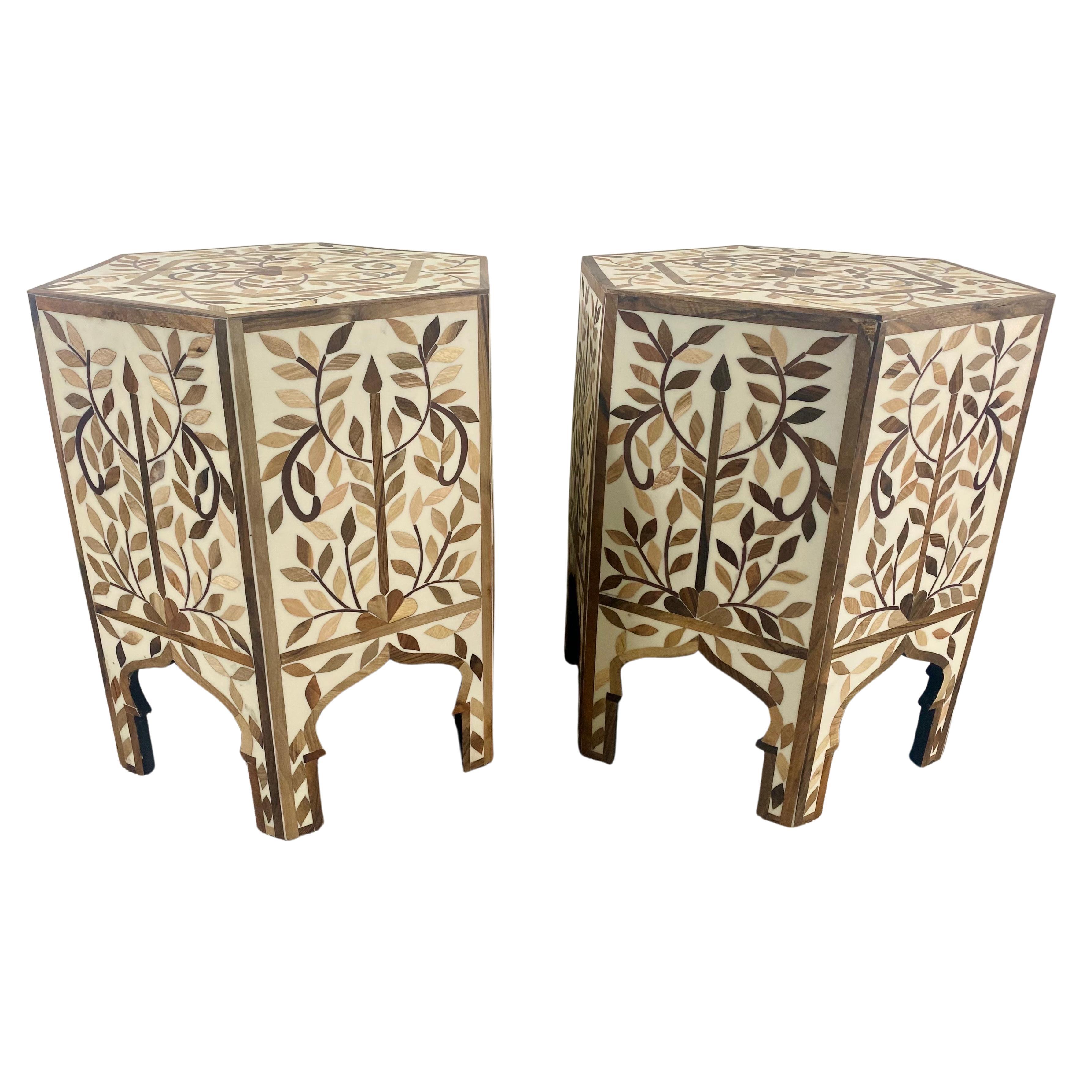 Una squisita coppia di tavolini boho chic marocchini dalla forma esagonale. I tavoli fatti a mano sono finemente decorati con motivi a foglie e splendidi archi, un punto fermo dell'architettura e del design moresco senza tempo. Realizzati a mano in