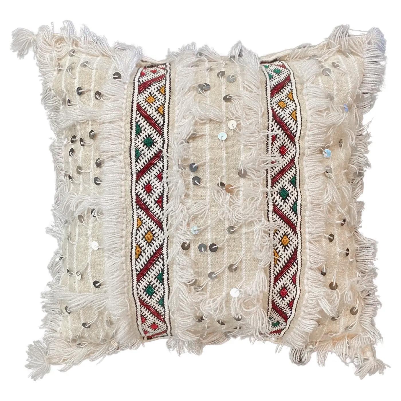 Handcrafted by Berber women in the Azilal region of Morocco, this pair of pillows is handmade with local organic wool and adhered with sequins for extra detail. Boasting unique color schemes and fringed edges, the Moroccan Wedding Pillows' intricate