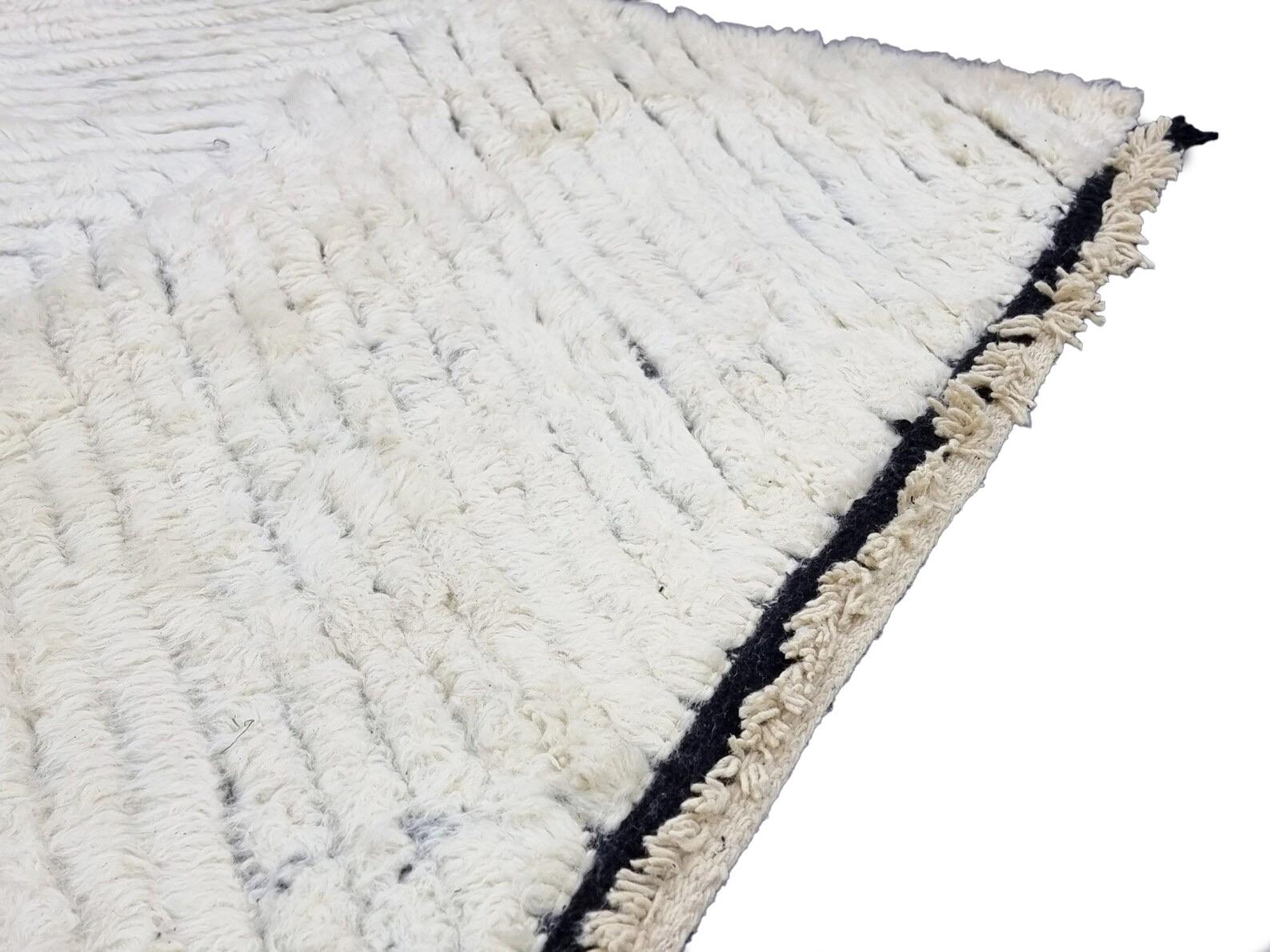 Moroccan Boujaad rug in white and black striped wool handwoven high in the Atlas mountains by the Ben Ourain tribe using techniques handed down generation to generation. Every handmade rug is washed and dried in the mountain air and made with the
