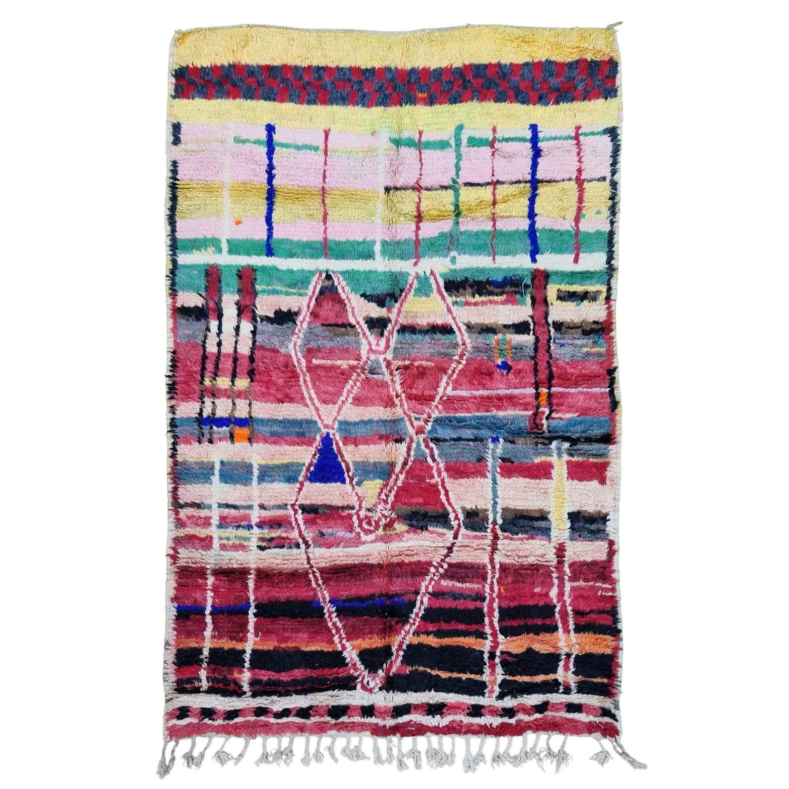 Moroccan Boujaad multi-colored striped rug handwoven out of natural and soft sheep wool featuring bright red, pinks, mauve, red, orange, or beige background, along with irregular geometric patterns blending Arabic and Berber cultures in Morocco. The