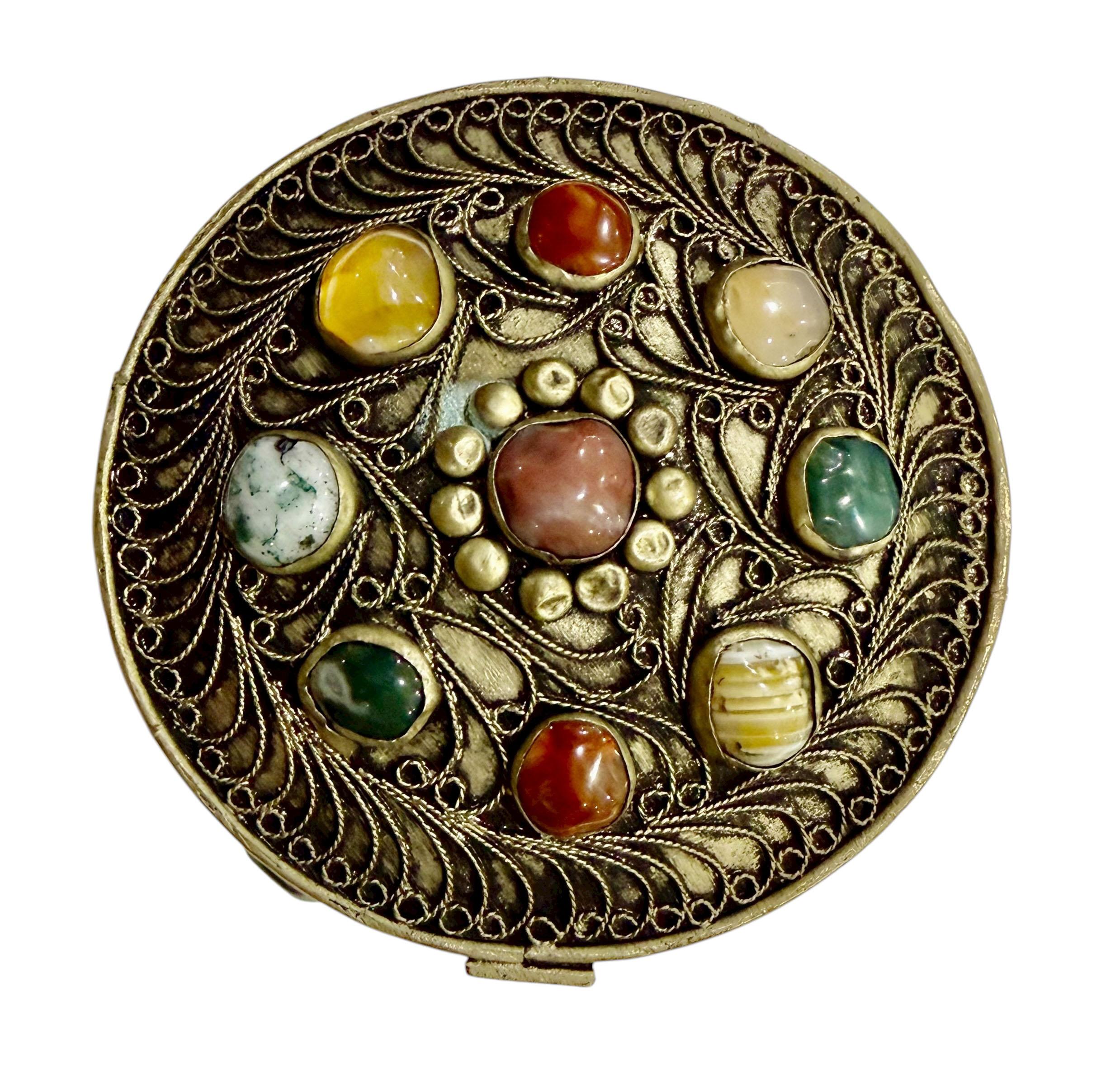 A captivating Round Moroccan Box crafted from white metal and adorned with semi precious stones, exemplifying the intricate artistry and vibrant spirit of Moroccan design.

This exquisite piece features a beautifully hand worked white metal surface