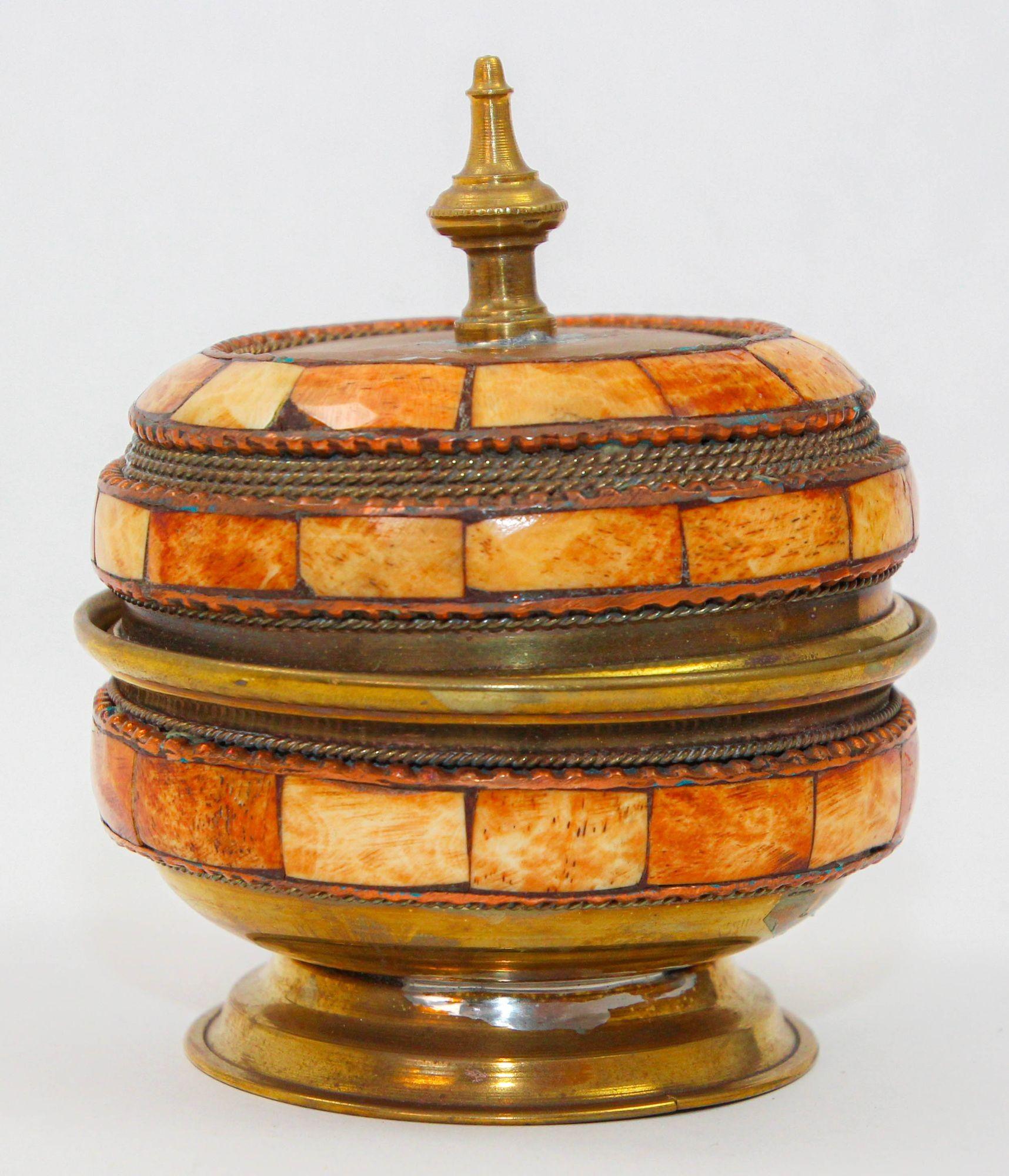 Vintage Moroccan footed box, handcrafted from brass with overlay carved bone in orange amber color and white.
Decorative Moroccan vintage brass canister with removable lid.
Handcrafted in Marrakech Morocco, circa 1950.
Condition, patina on brass
